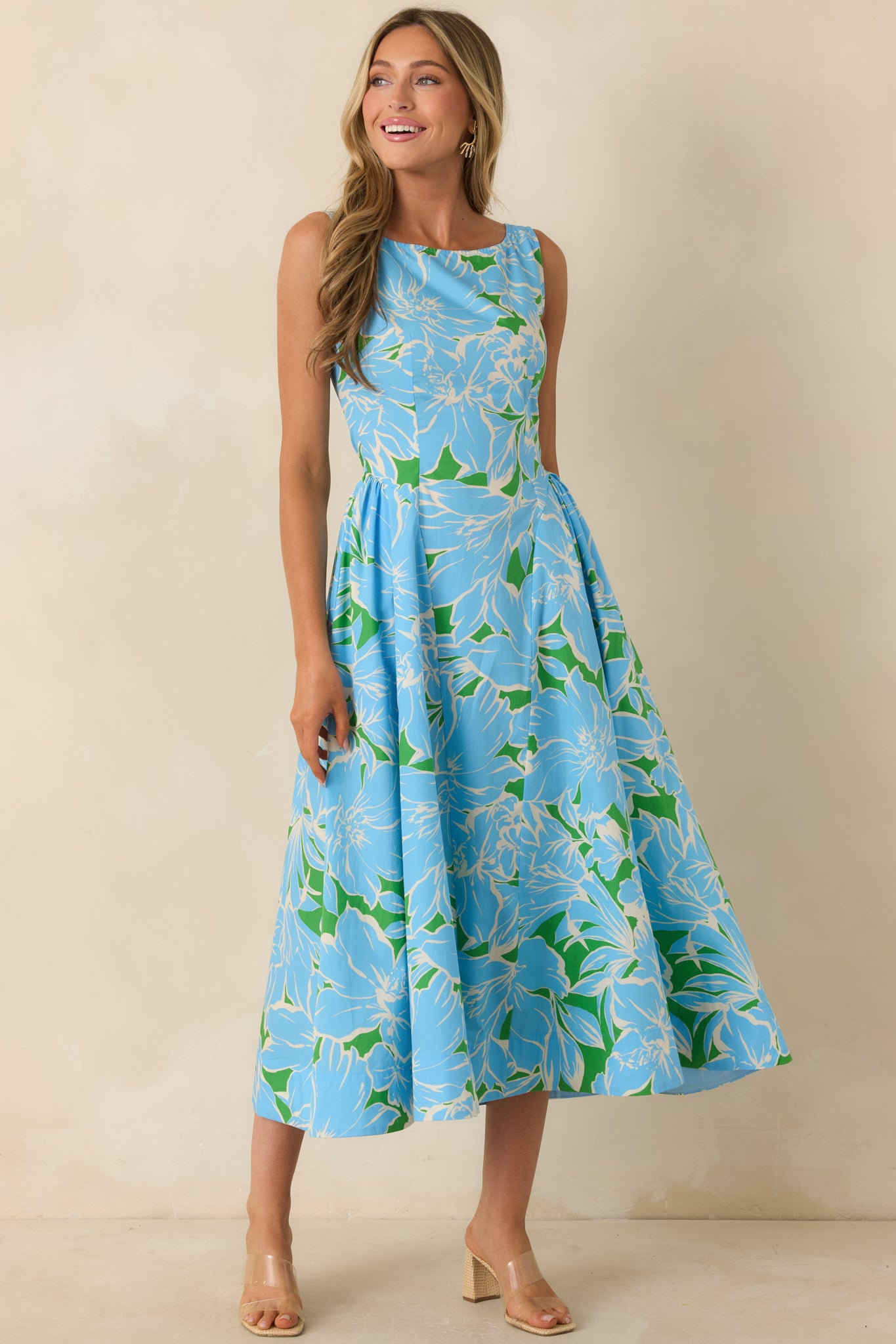 Vintage-inspired floral midi dress with a vibrant blue and green print, tailored bodice, and twirl-worthy midi-length skirt.