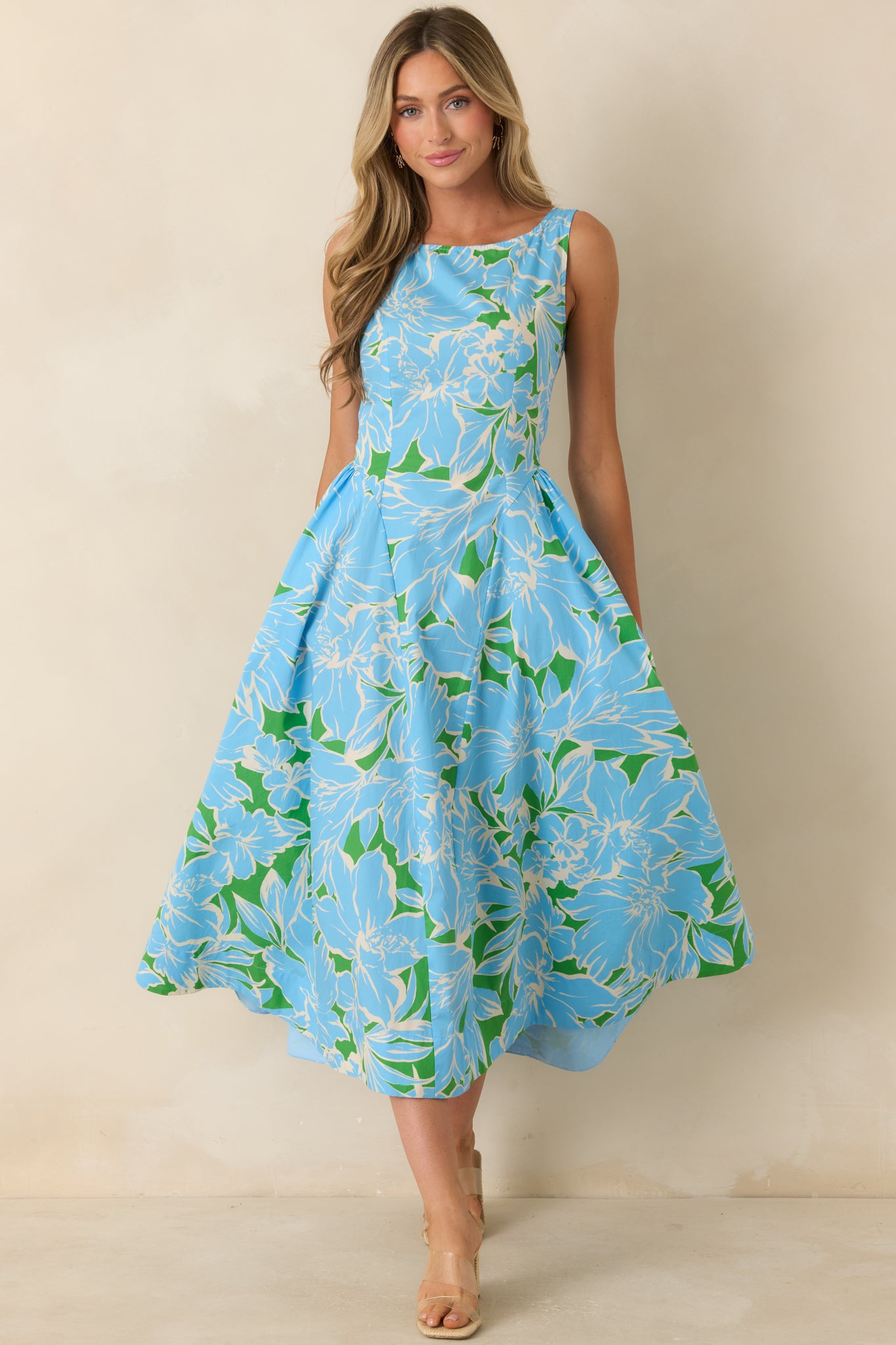 Blue and green floral midi dress featuring a classic sleeveless design, defined waist, hidden side pockets, and a beautifully flared skirt for an elegant silhouette.