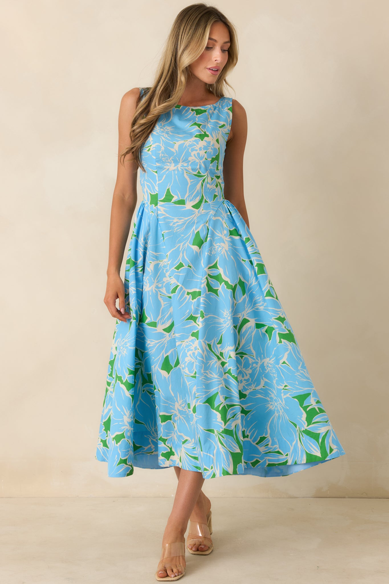 Blue floral midi dress with a flattering fitted shape, feminine silhouette, practical side pockets, and elegant movement throughout the skirt.