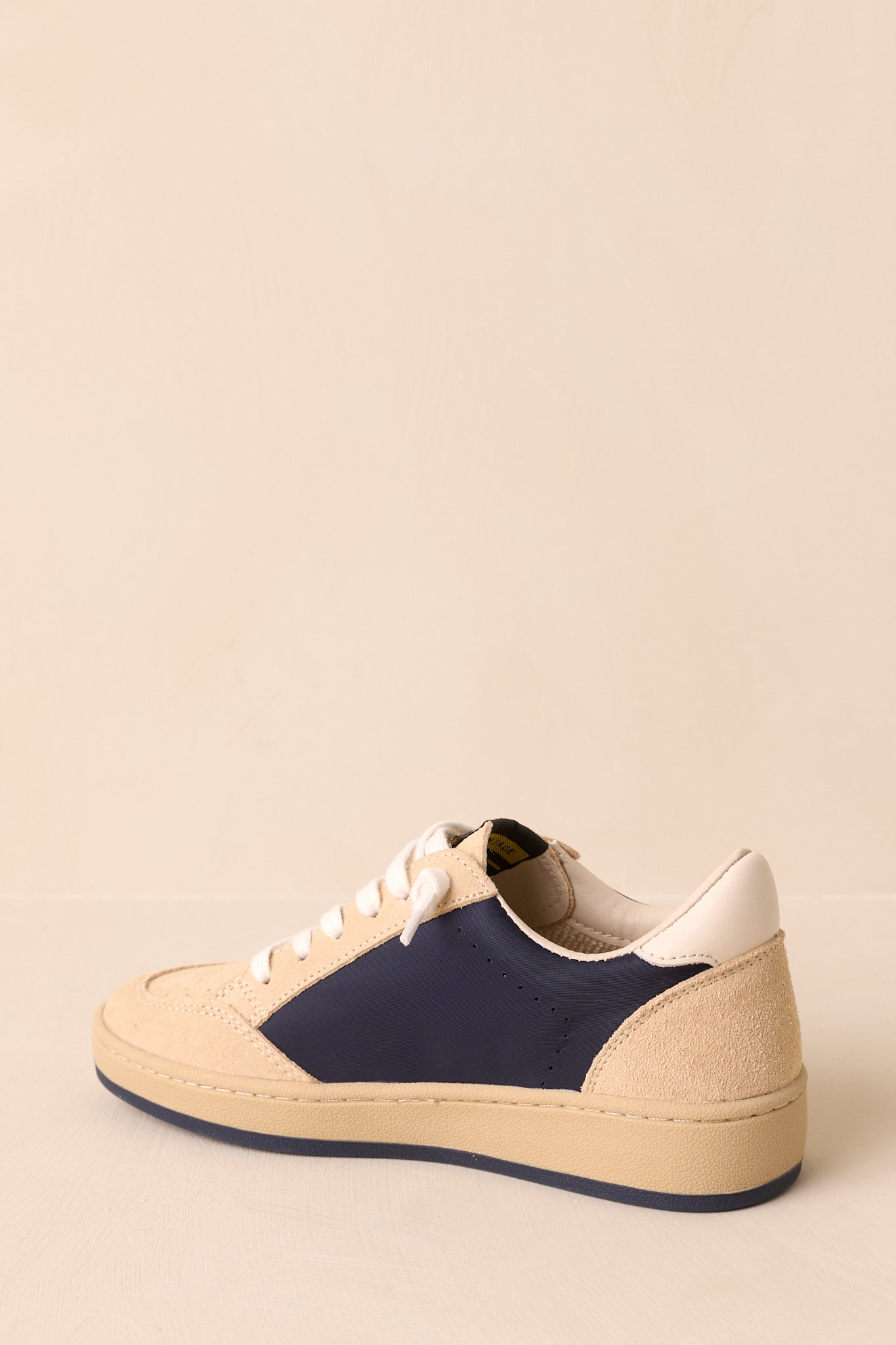 Back view of the sneakers showing the cushioned heel collar, clean heel counter, and flat tonal rubber outsole.