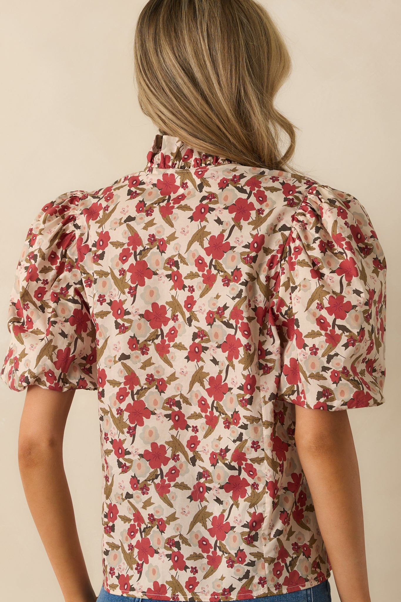 A back view of the top showing the puff sleeves, structured silhouette, and allover floral pattern.