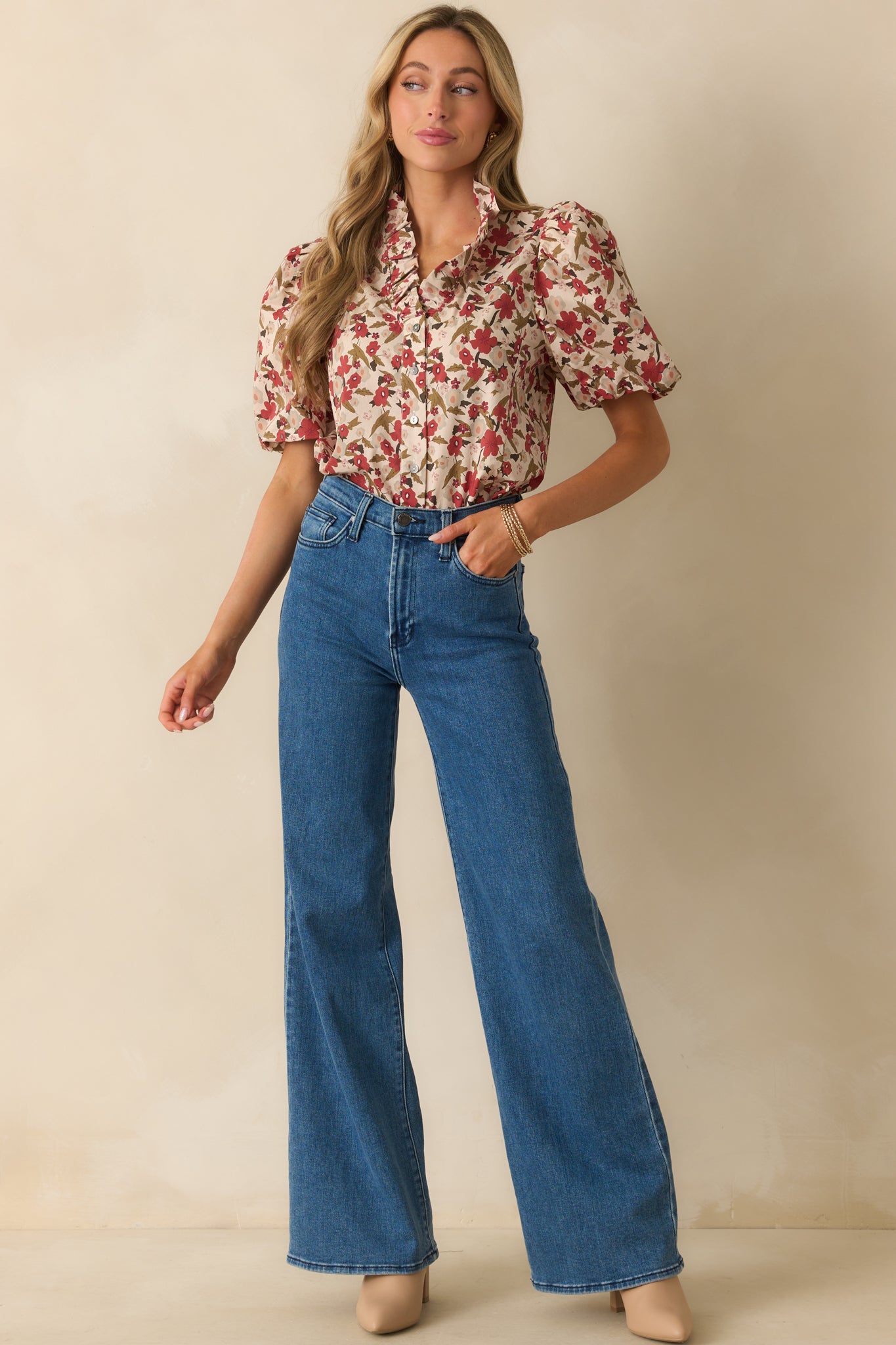 A full body photo of the ecru beige floral top, emphasizing the ruffled neckline and tailored shape.