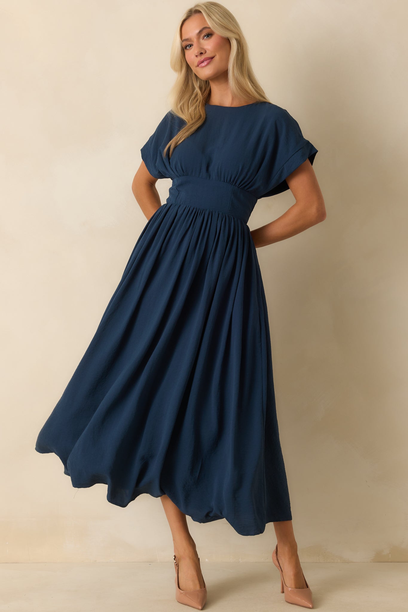 Short sleeve navy dress styled with a flattering waist and full-length silhouette.