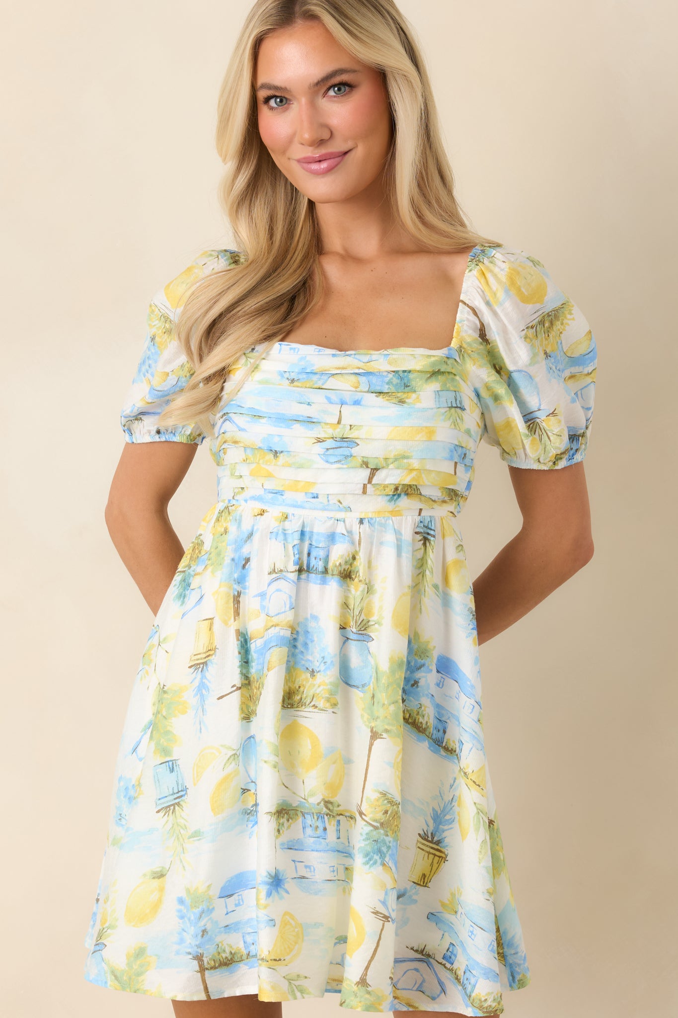 Smocked back panel detail on blue and yellow printed mini dress for flexible fit.