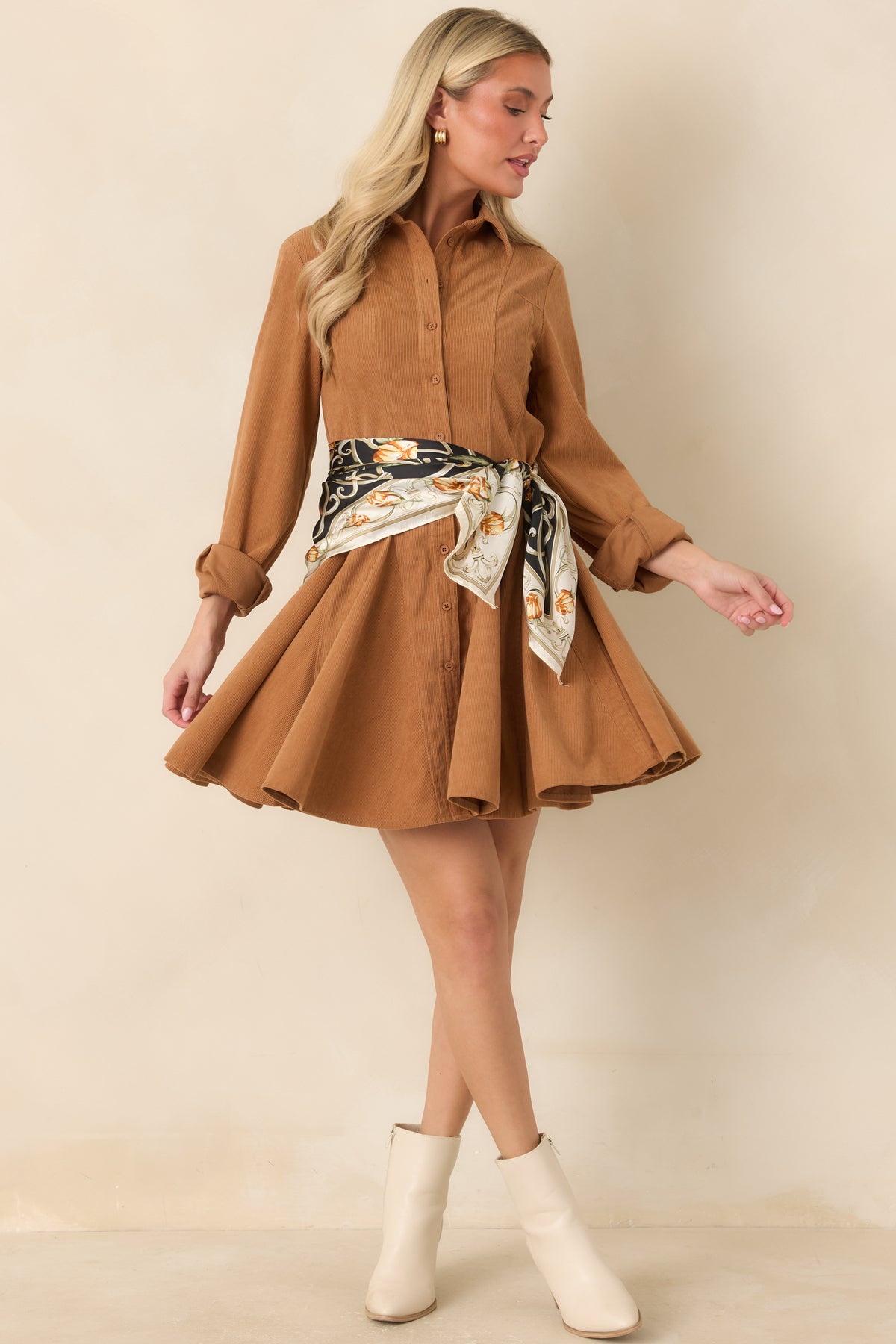 Golden camel corduroy mini dress with a pointed collar, long sleeves, full button front, and flared skirt.