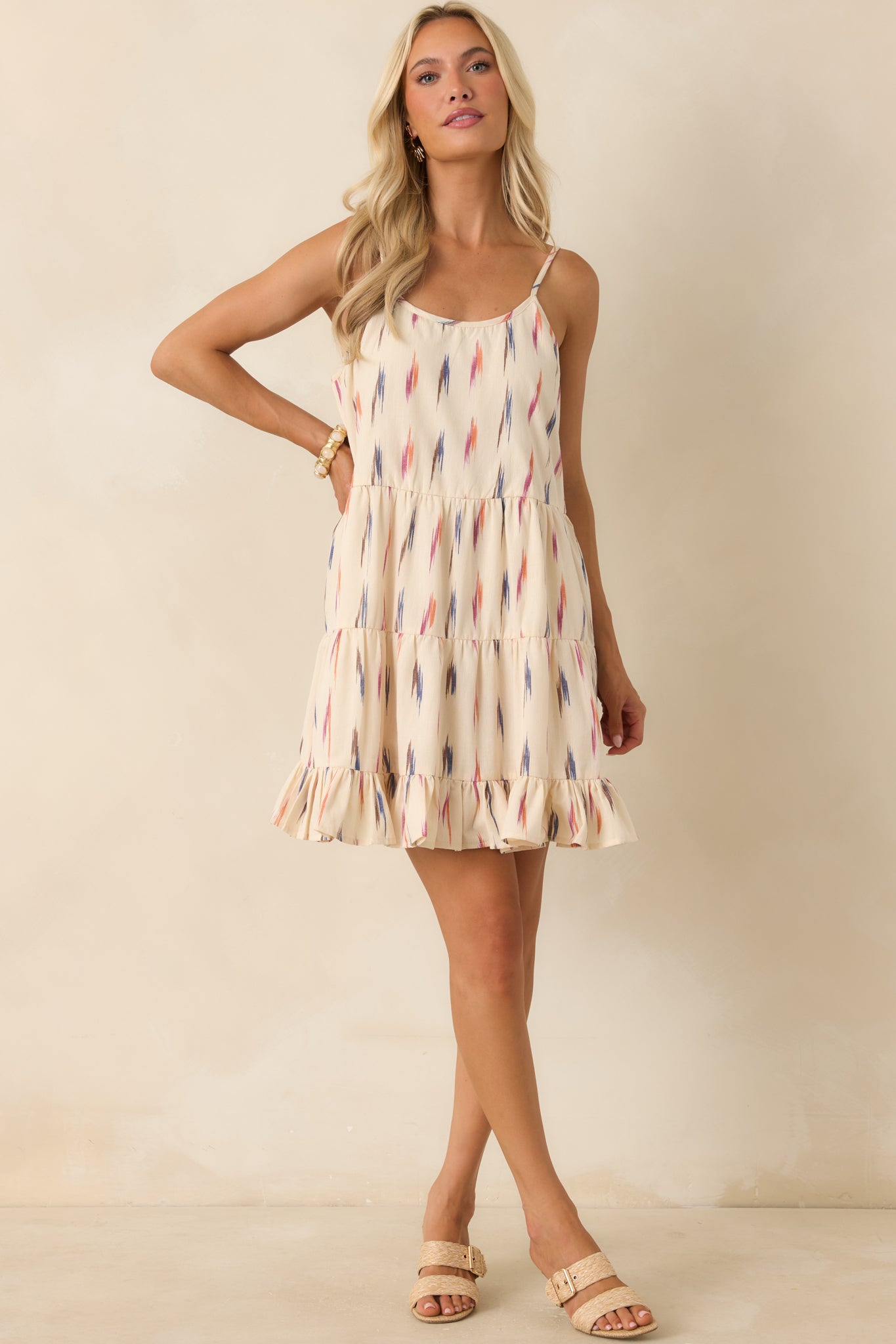 All-cotton mini dress in an ivory multi print with adjustable straps, a relaxed fit, and layered tiers.