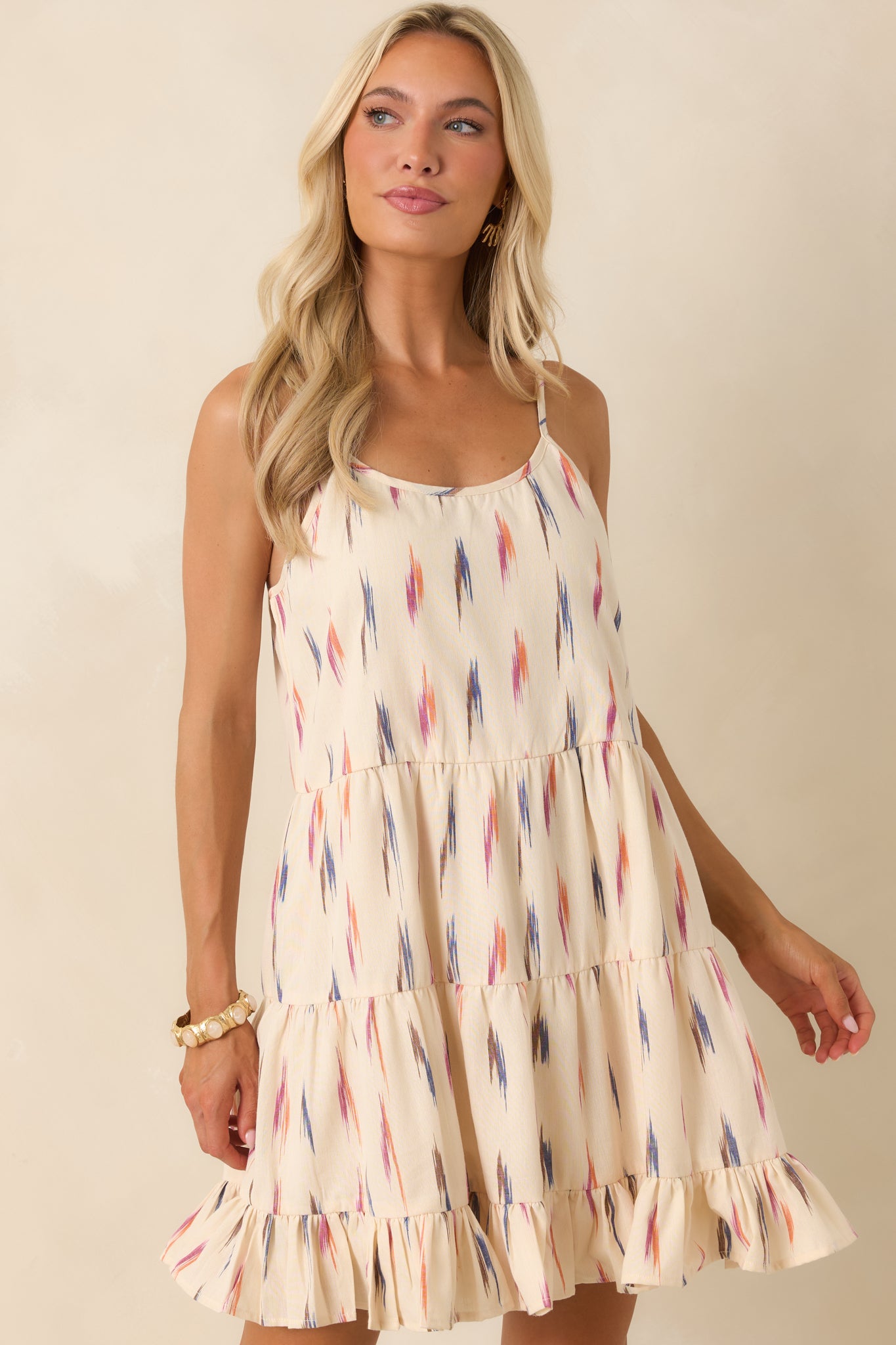 Ivory multi print dress featuring a close-up of the bodice, scoop neckline, and flowing tiered silhouette.