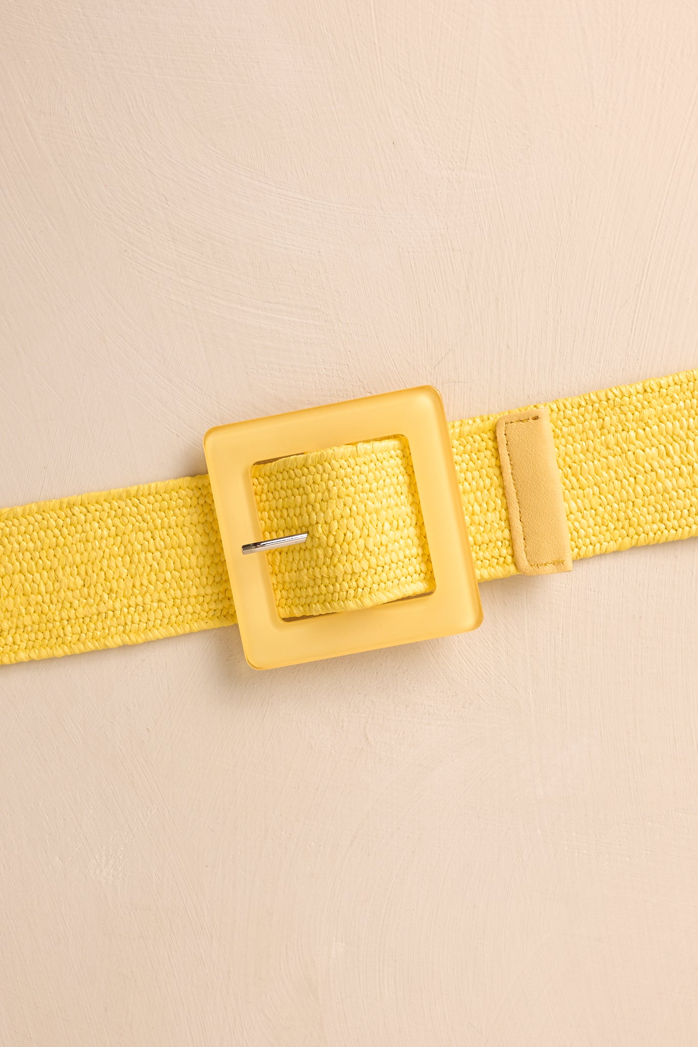 Detailed close-up of yellow belt showcasing woven elastic material and square acrylic pin buckle.