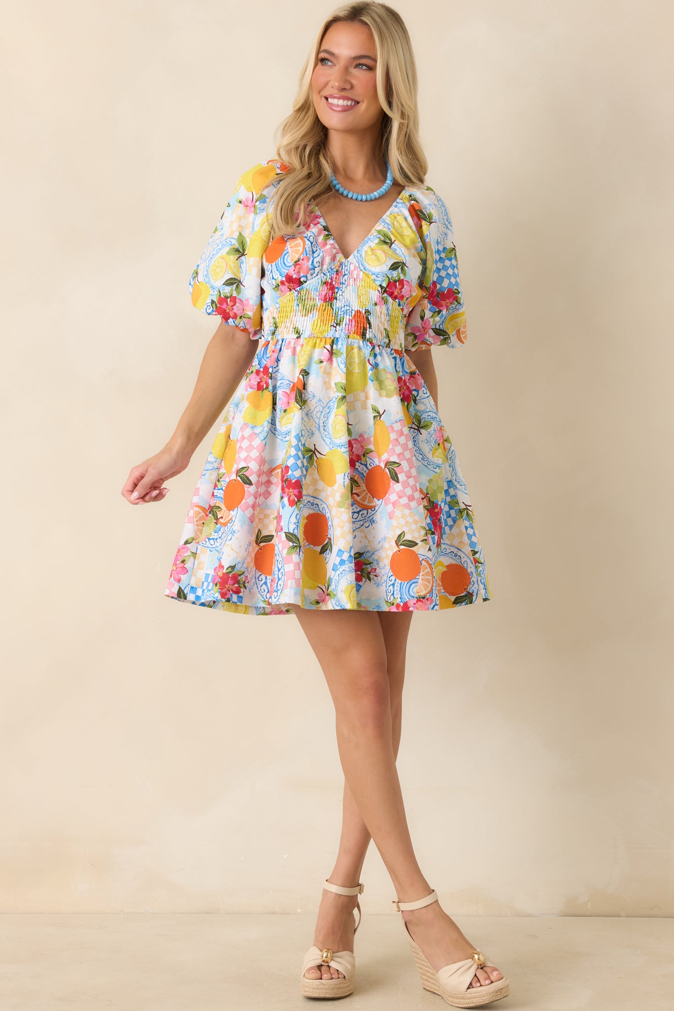 Mini dress highlighting a smocked empire waist that creates gentle shaping before flowing into a relaxed silhouette.