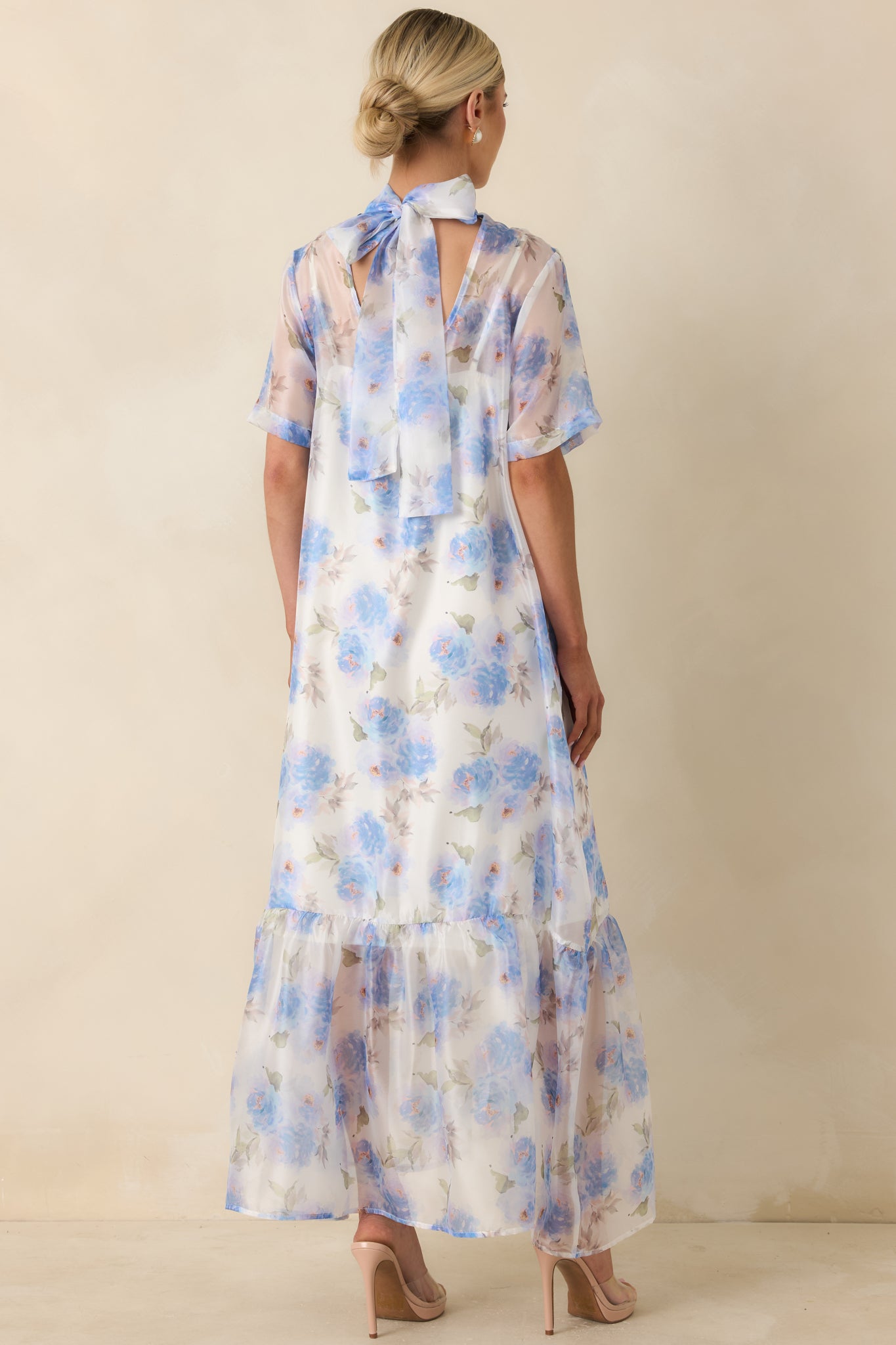 Back view of the blue floral maxi dress featuring the keyhole closure, relaxed silhouette, and tiered ruffle hem.