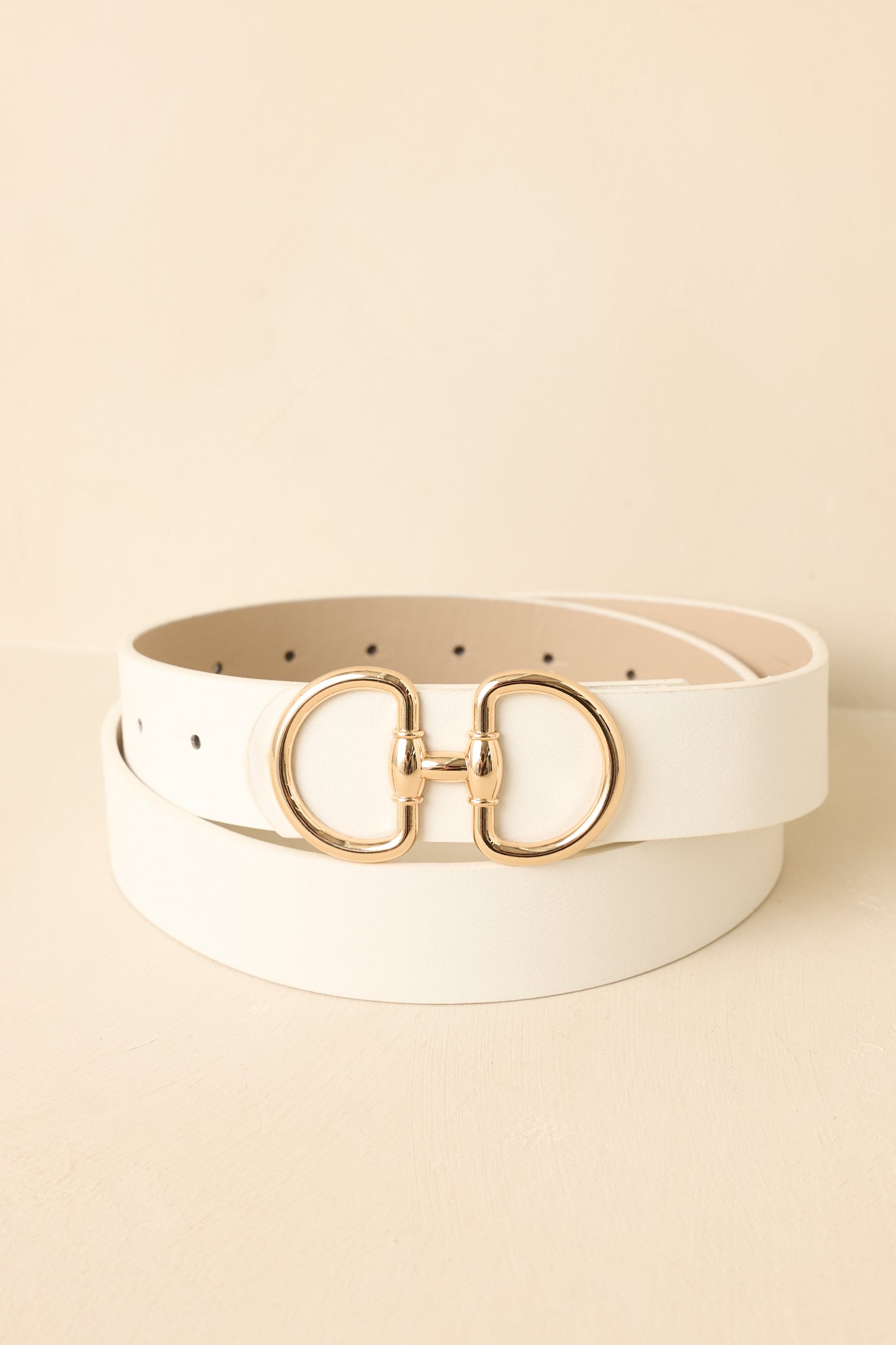 Cropped view of white belt featuring a link-style buckle with two prongs and gold-tone hardware.