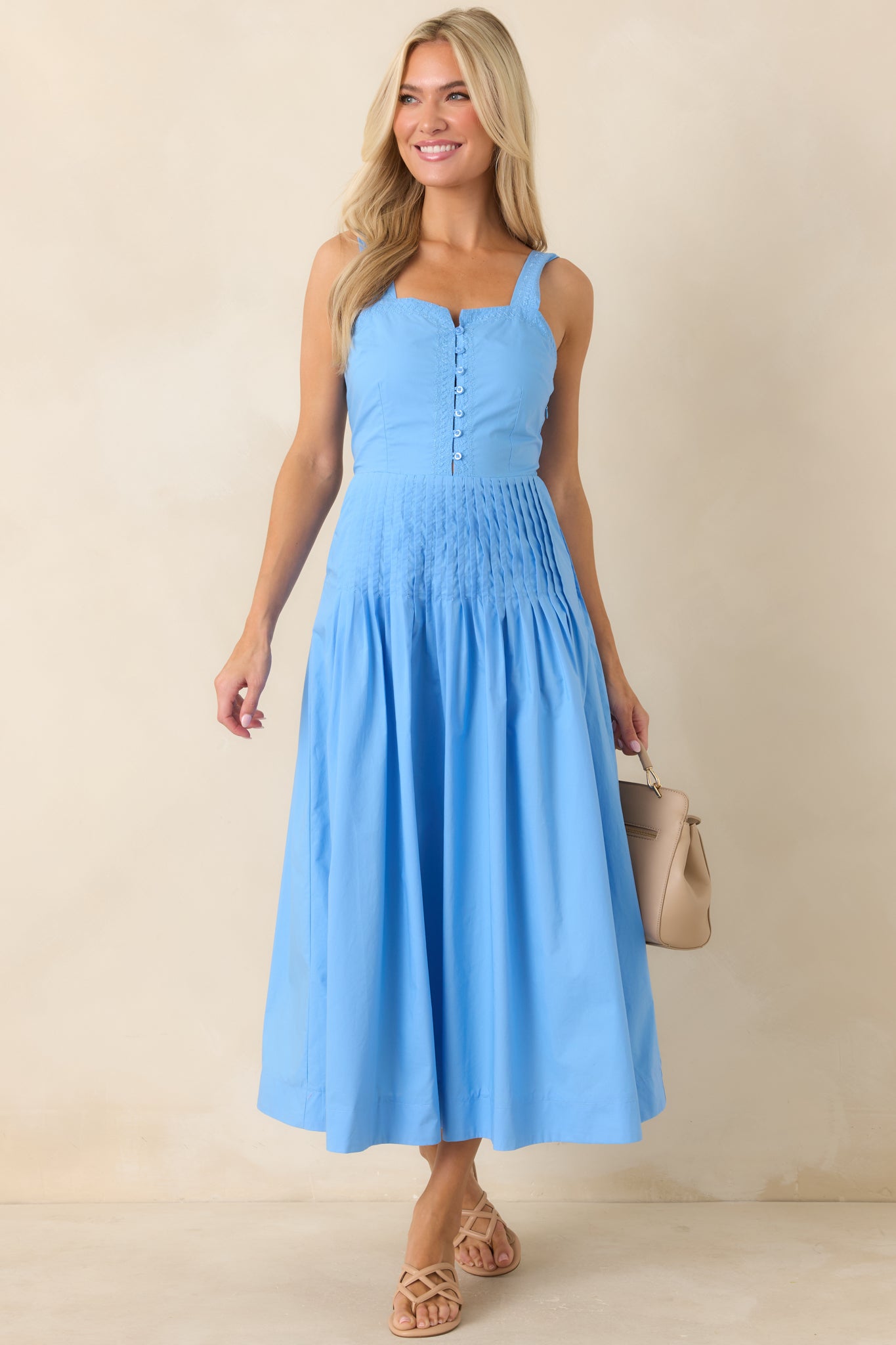 Breathable 100% cotton dress with button-front detail and pleated waistline for a structured silhouette.