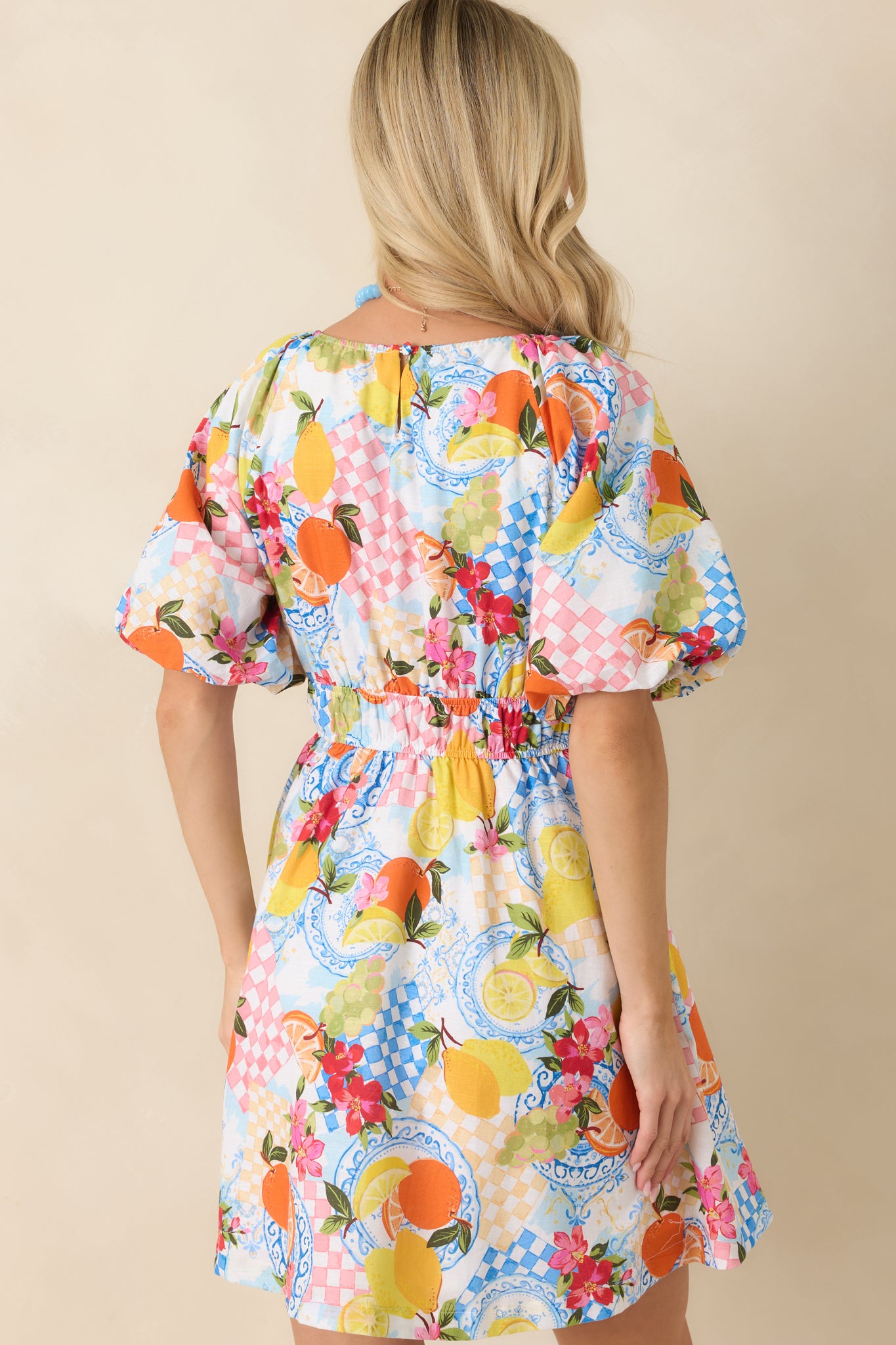 Rear view of the citrus print mini dress showing the continuous allover pattern and relaxed drape through the back.