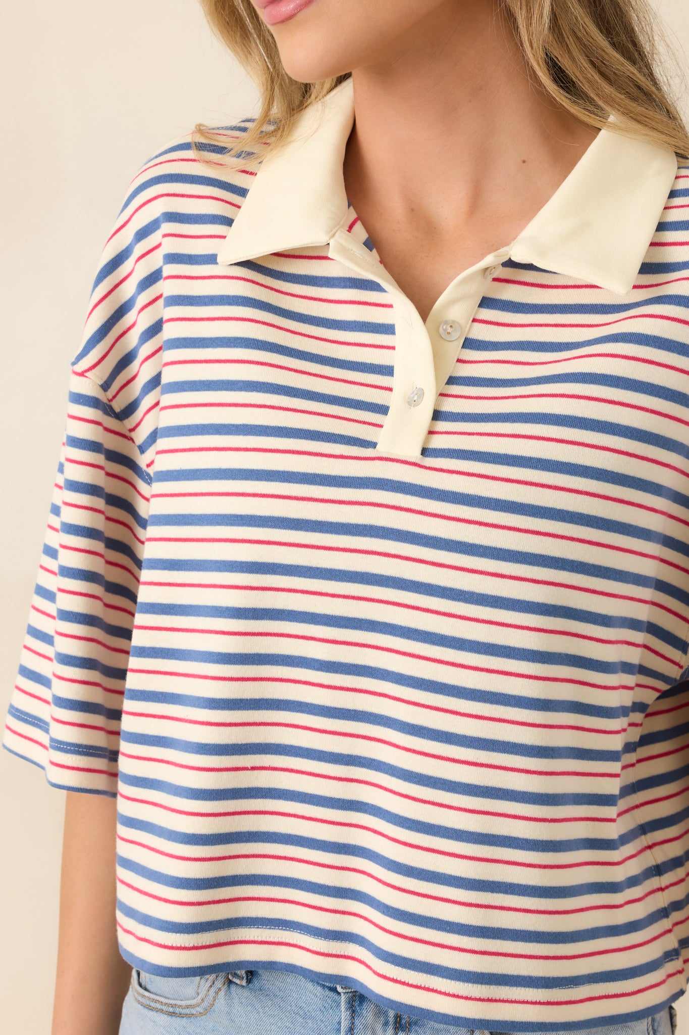 Close-up of blue multi-stripe fabric, solid contrast collar, and partial button placket.