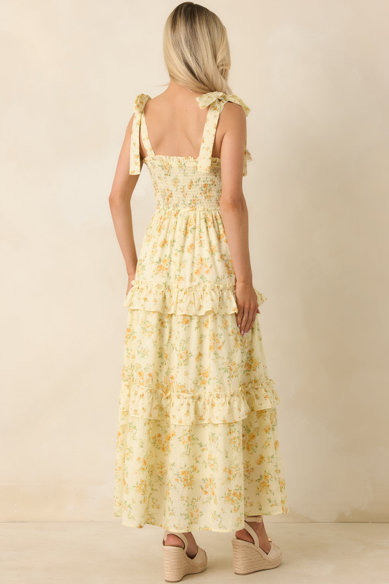 Rear view of floral midi dress with smocked back bodice and tiered ruffle skirt.