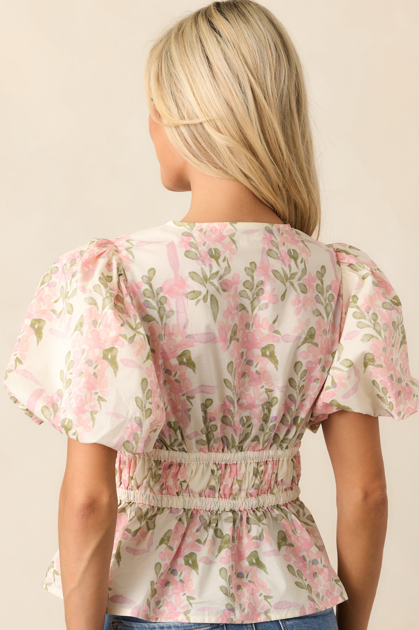 A back view of the blue blouse, displaying the puff sleeves and continuation of the floral pattern.