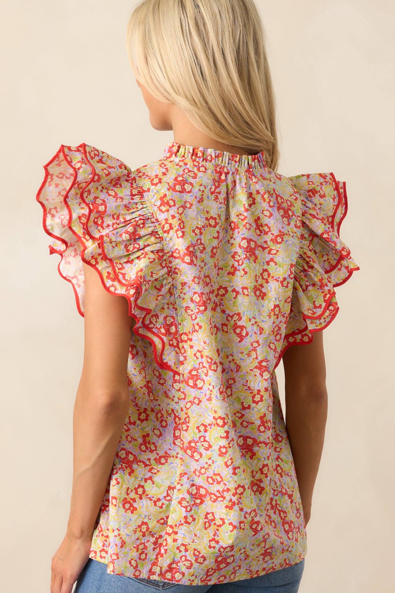 A back view of the red floral top, displaying the continuation of the print and the back flutter sleeve design.