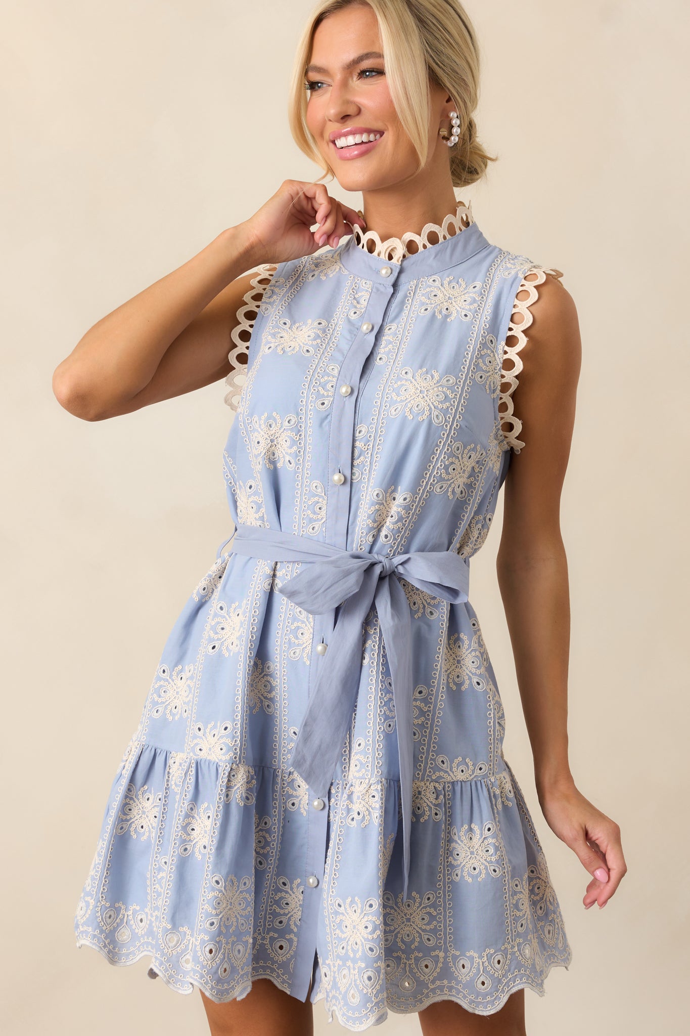 A side angle of the blue dress, highlighting the checkerboard embroidered detail and sleeveless design.