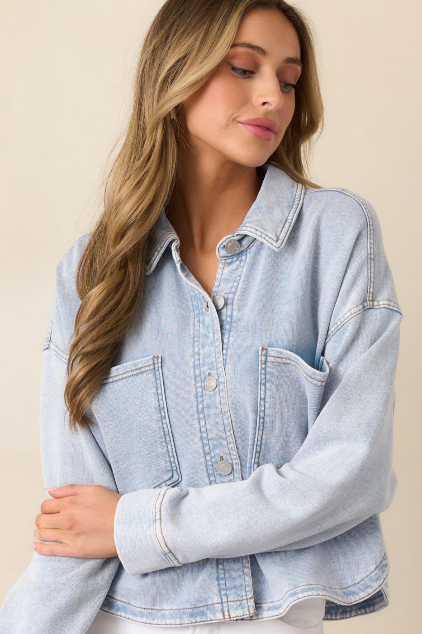 A close-up image focusing on the collar and top button, displaying the worn denim texture.