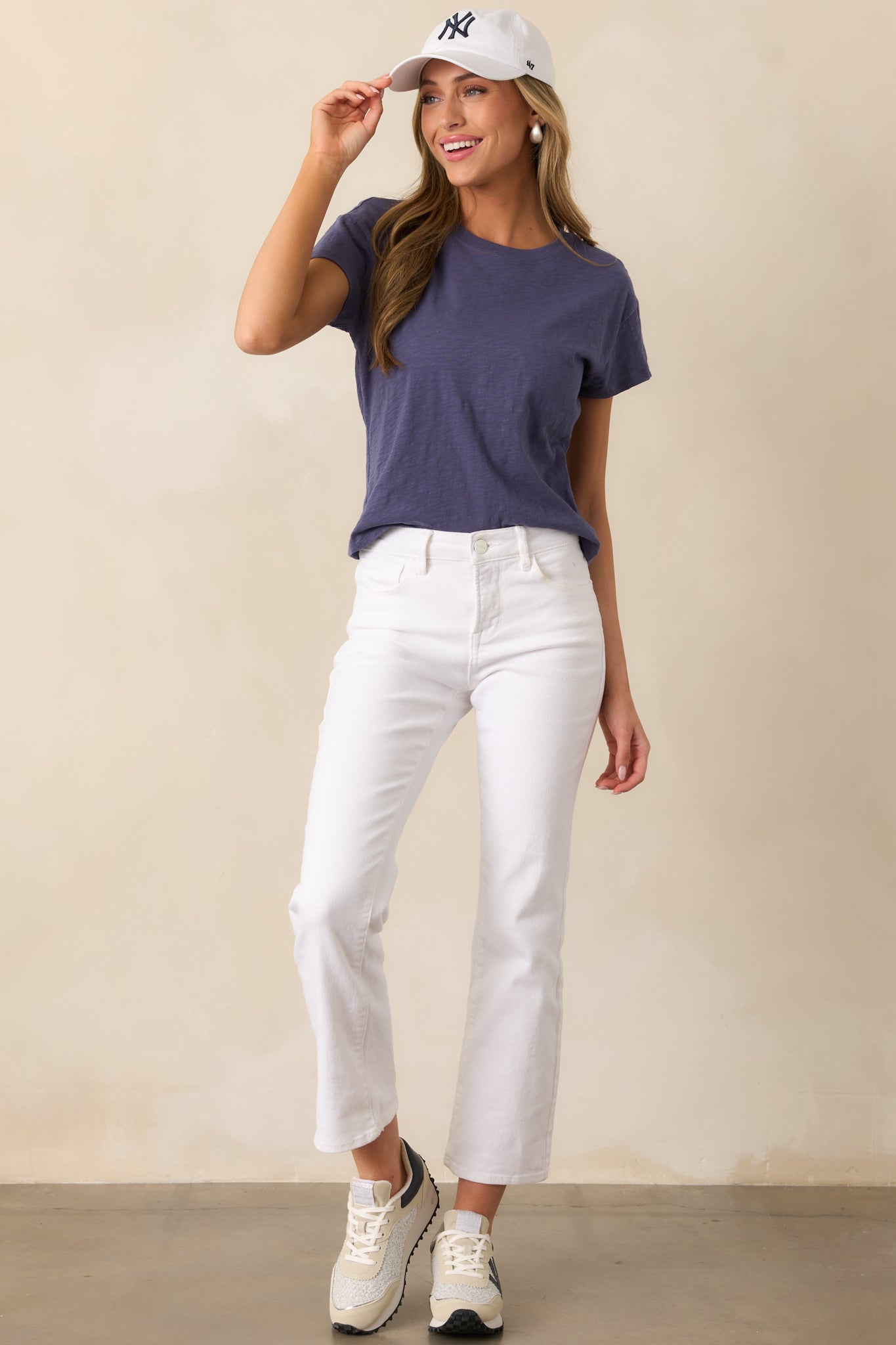 Chic white jeans featuring a high waist, button-zipper closure, and functional hip and back pockets, designed for a sleek, modern silhouette with a straight leg fit.