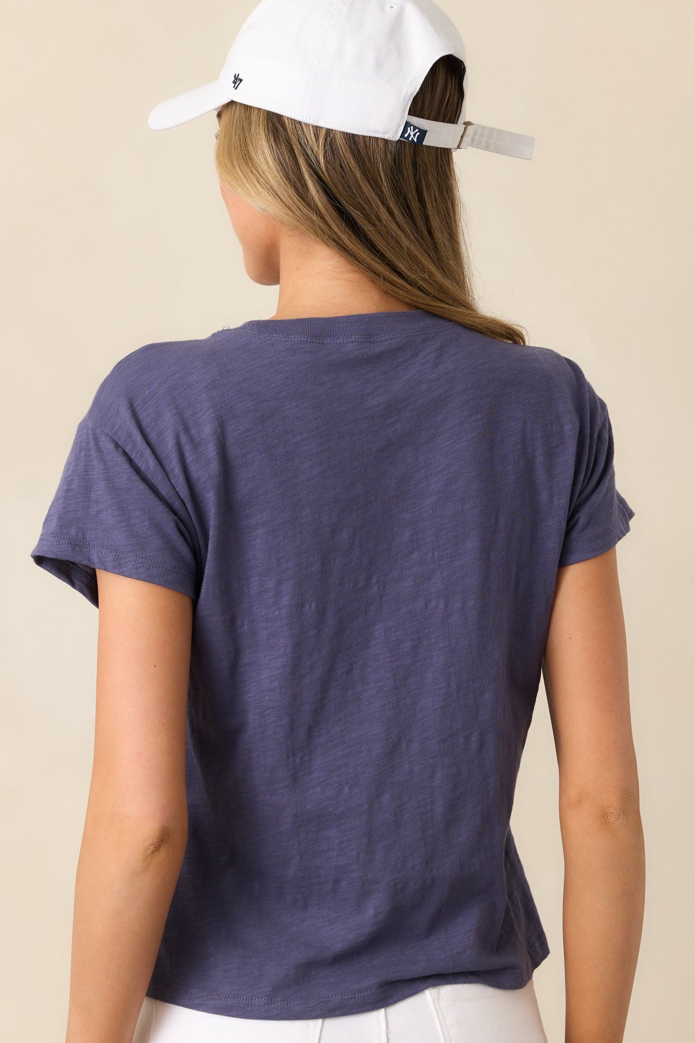 The relaxed silhouette continues in the back, showcasing the effortless drape and slightly cropped length of this worn blue tee.