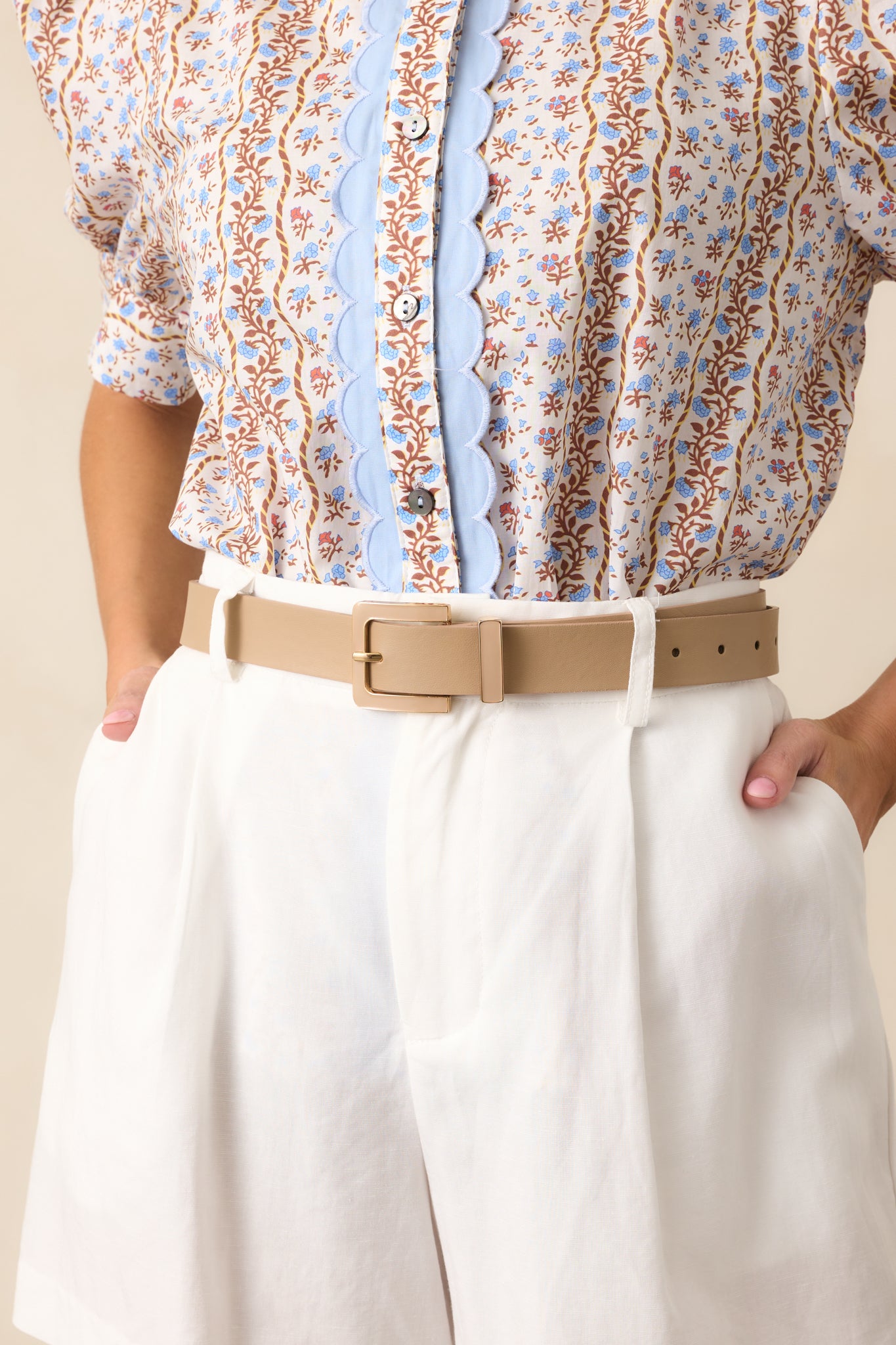 A front view of the tan belt, highlighting its thick smooth material and gold-bordered tan belt buckle.