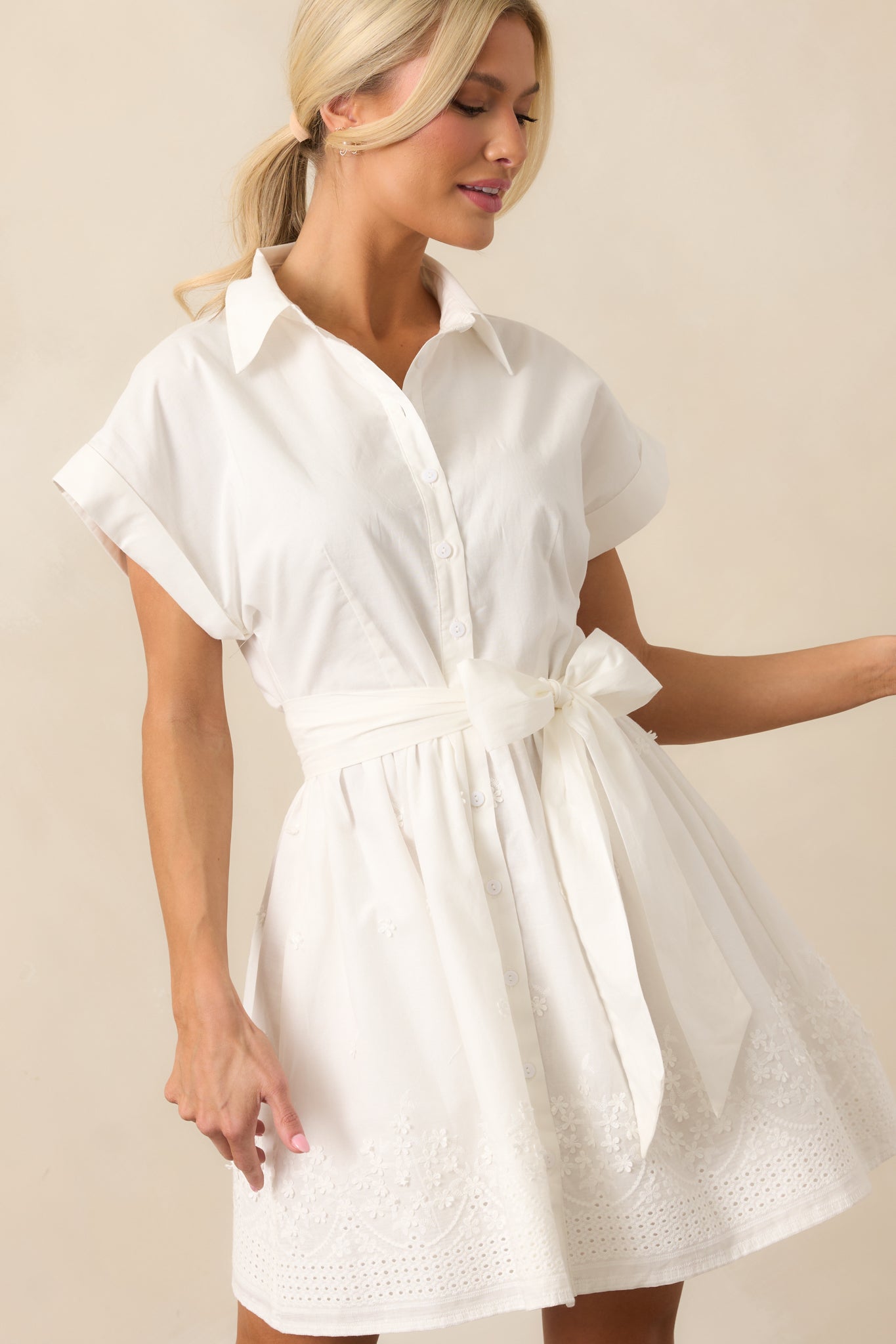 This shot highlights the embroidered hemline and self-tie waistband, with the button front design providing a classic touch to the dress.