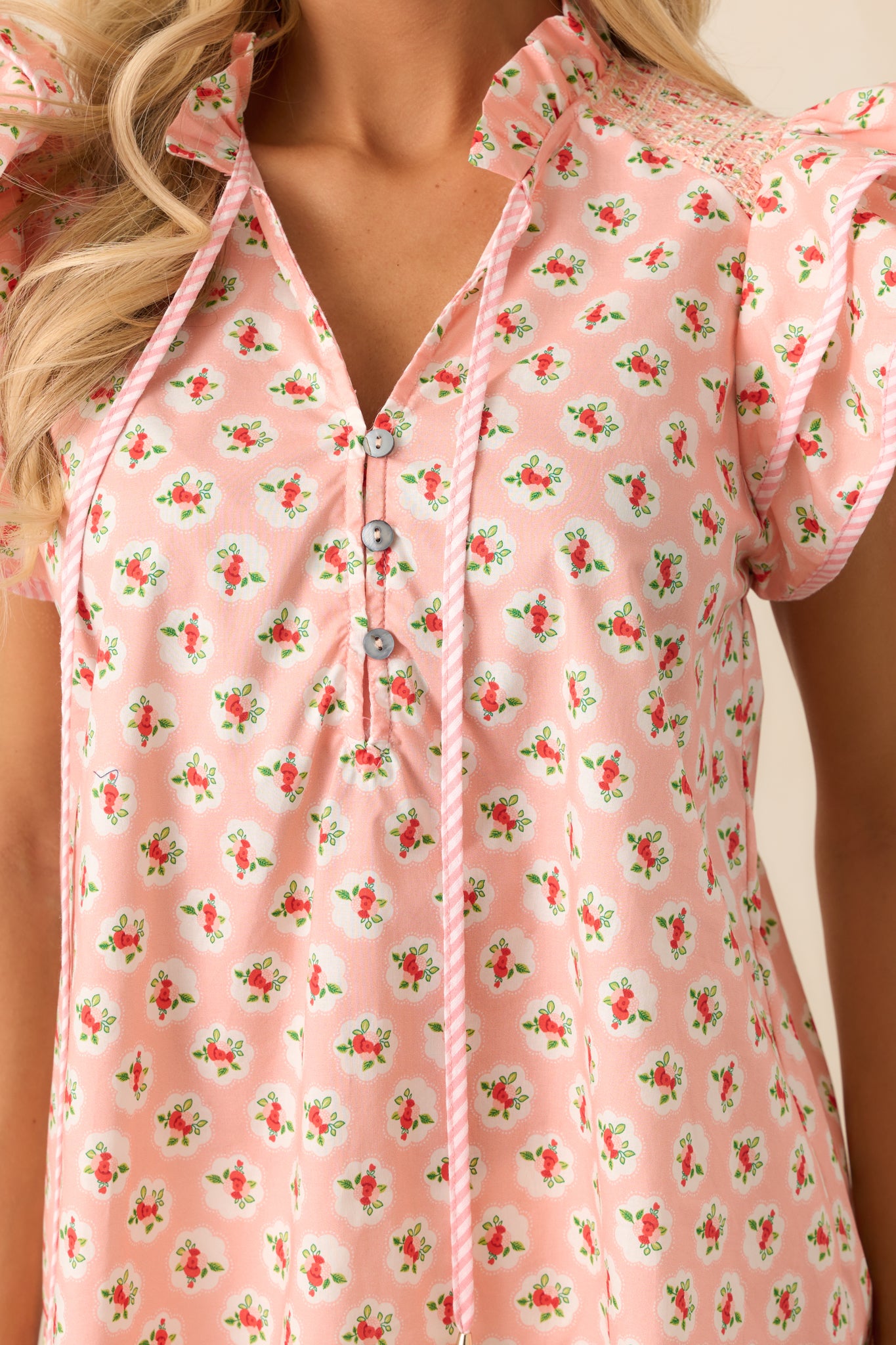 A close-up of the blouse's tie strings and ruffled collar, highlighting the playful yet sophisticated details that add charm to the overall design.