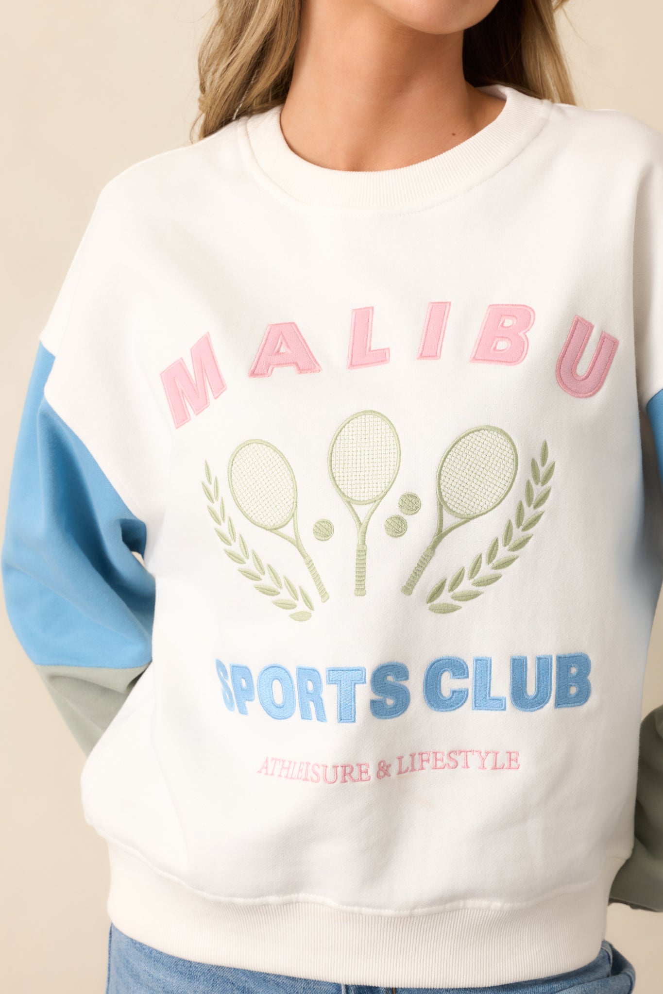 A closer view of the "Malibu Sports Club" embroidered graphic and the colorblocking detail on the sleeves, adding a fun, athletic touch.