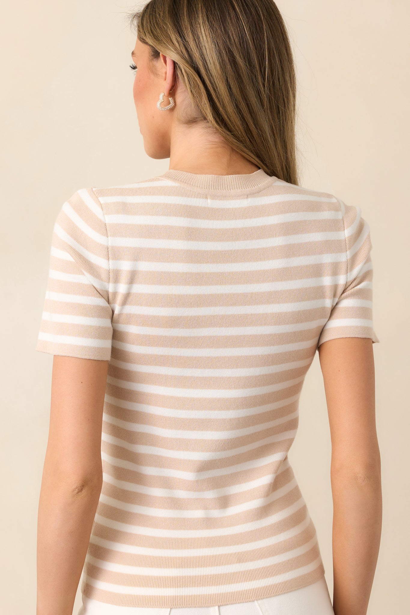 The back of this beige top continues the stripe design seamlessly, keeping the look cohesive and stylish.