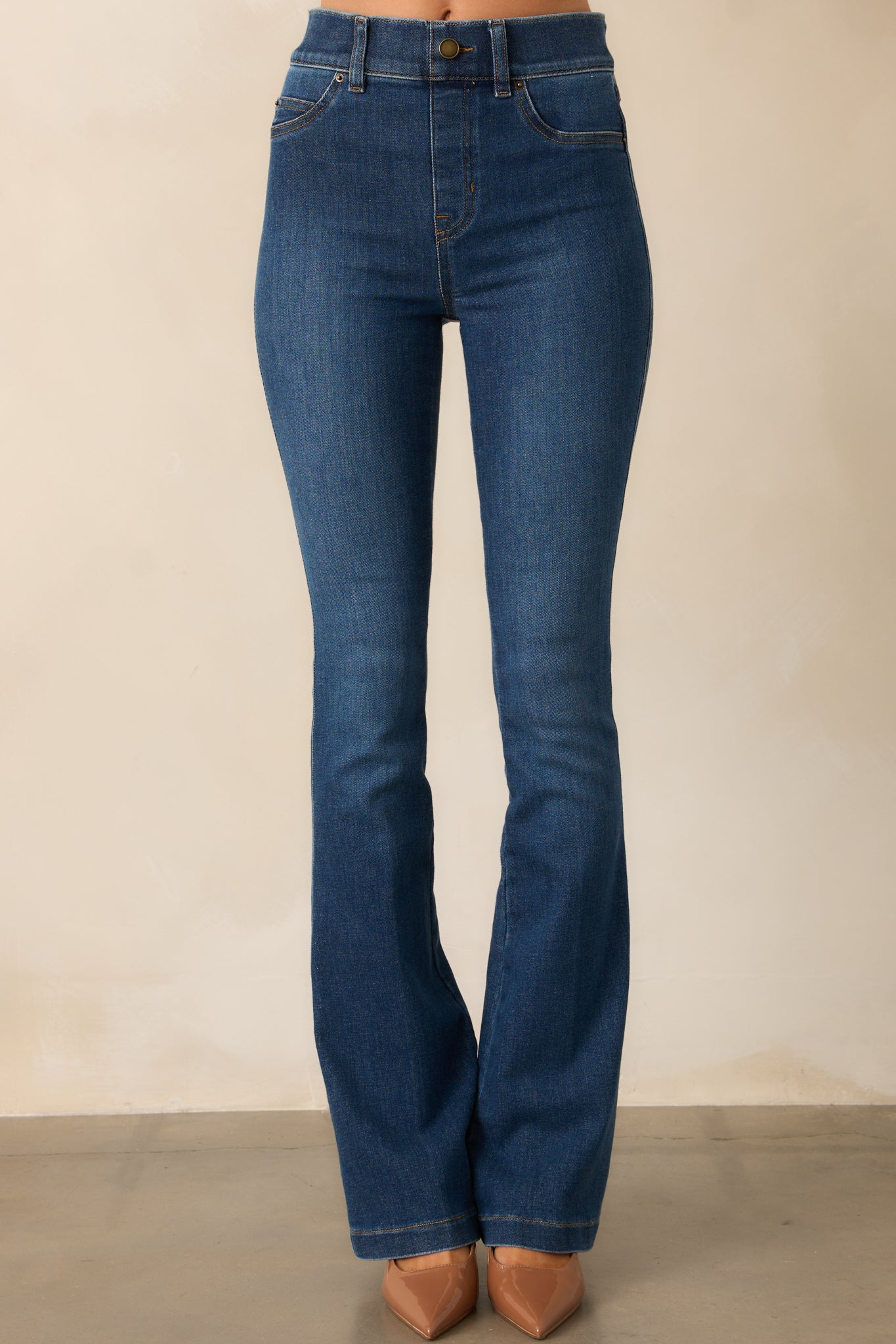 Smooth, stretchy fabric hugs the waist and hips, showcasing the seamless pull-on design and faux button detail.