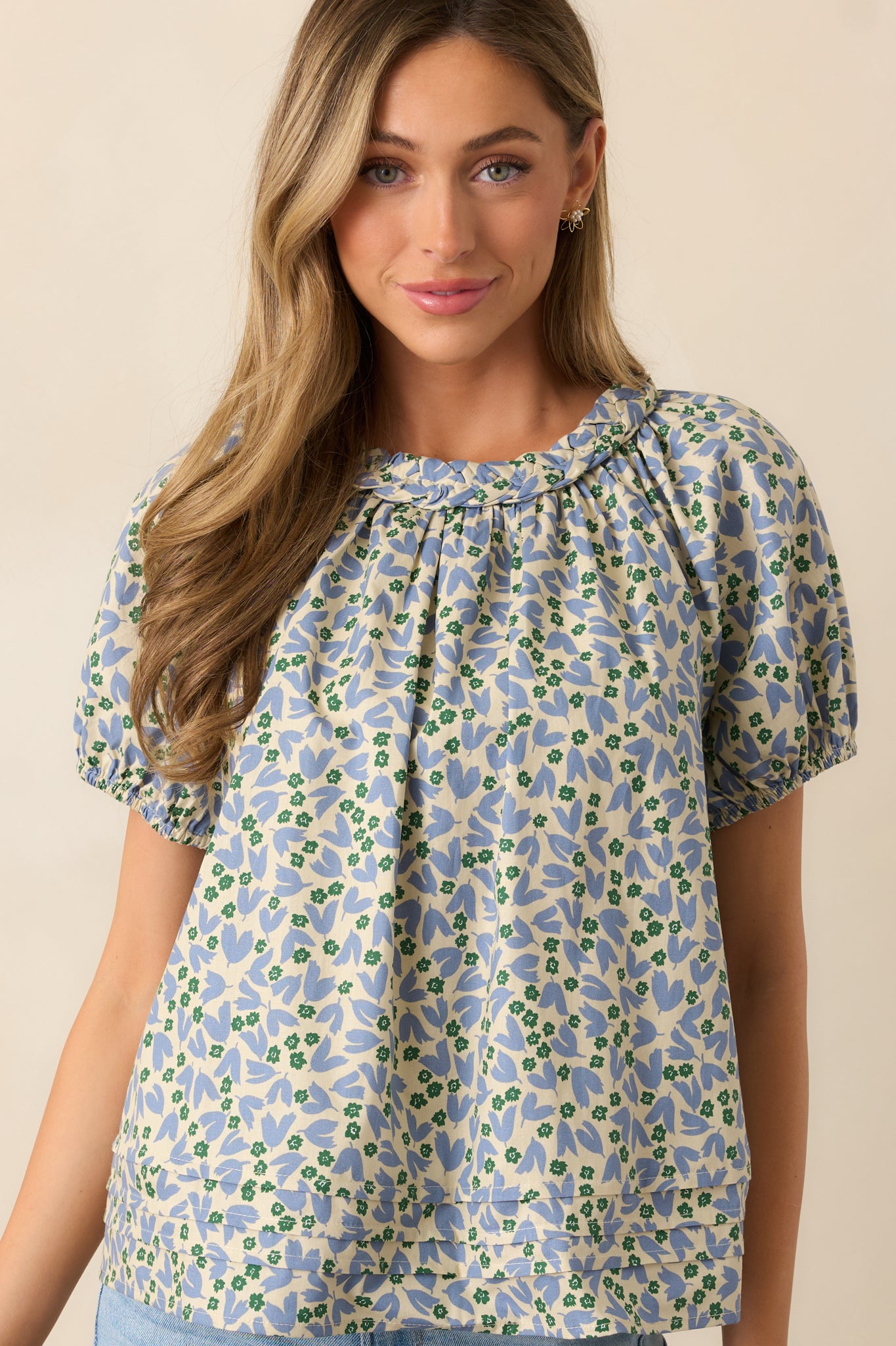 Full view of a dusty blue blouse with a relaxed fit, showcasing its tiered hem and flowy silhouette.