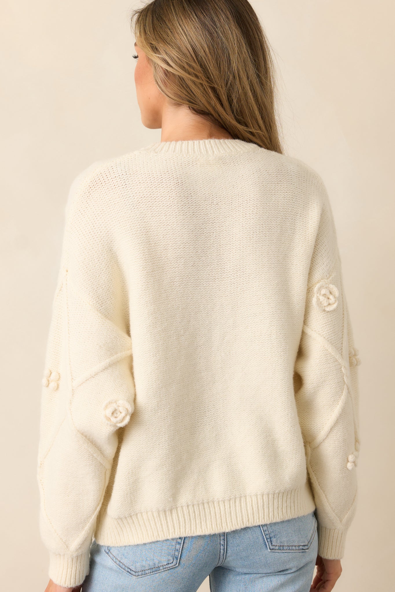 A view from behind, displaying the full knit pattern and ribbed cuffs on the long sleeves.