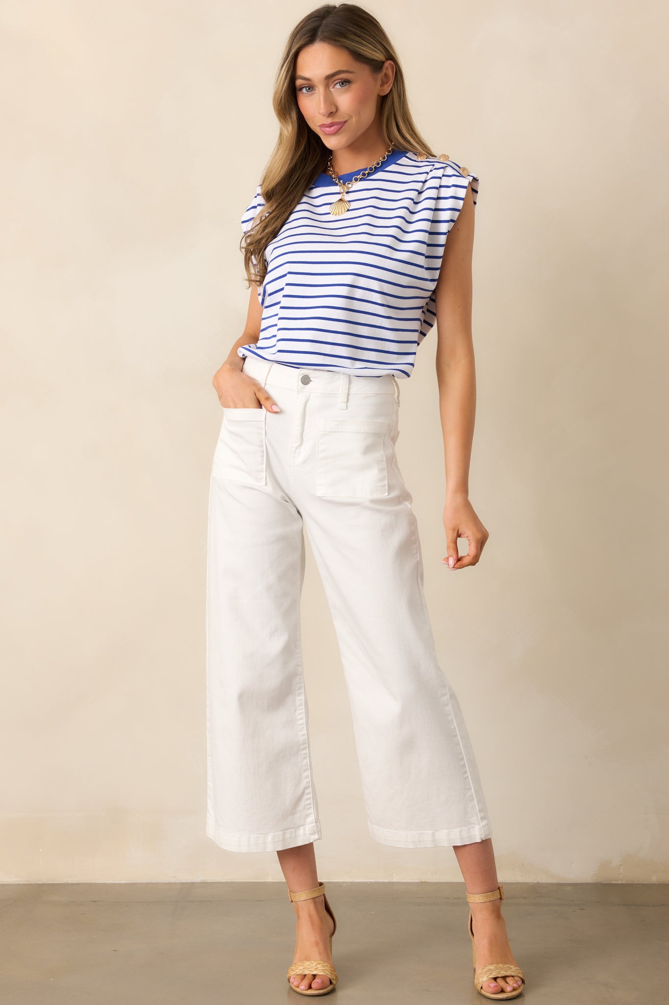 These ivory pants feature a high waisted design, classic button & zipper closure, belt loops, functional front pockets, faux back pockets, and a wide leg design.