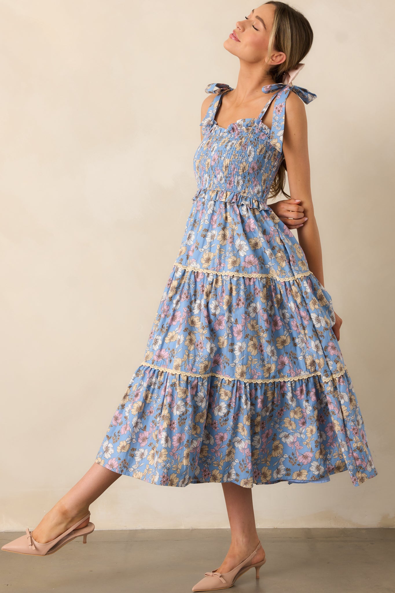 This ash blue dress is designed with a fully smocked bust, ruffle details in the bodice, and a lace tiered skirt, combining femininity and style in one piece.