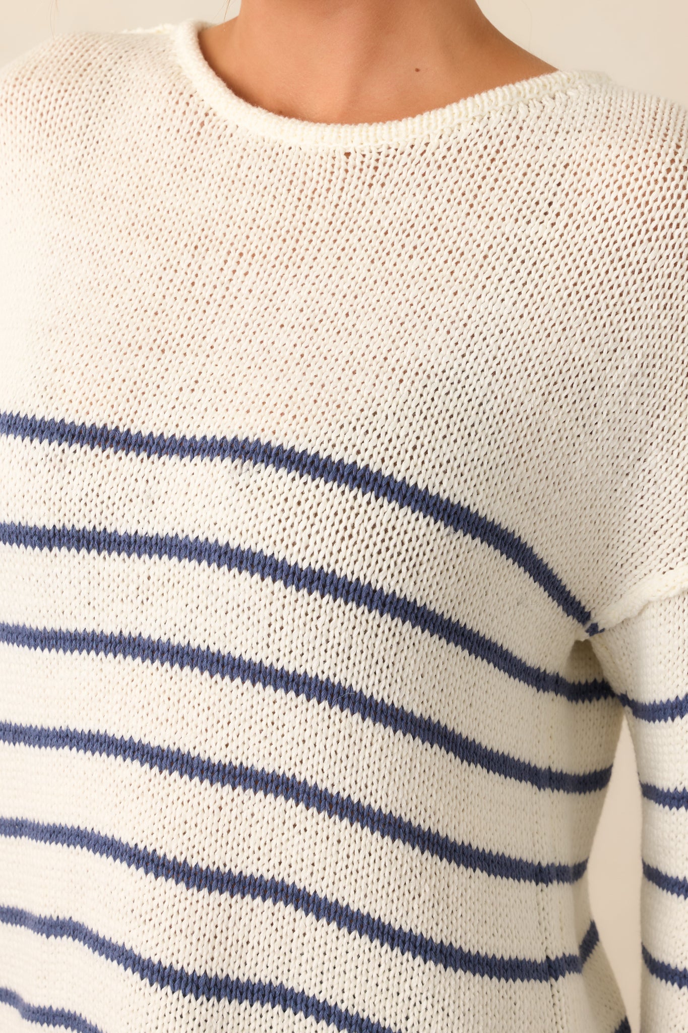 A detailed look at the navy stripes on the ivory fabric, highlighting the contrast and texture of the sweater.