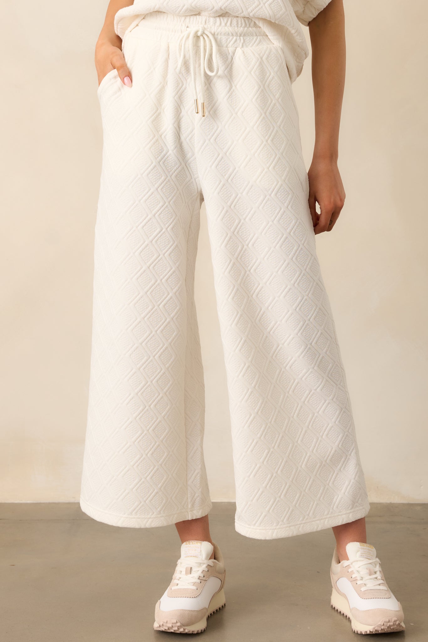 A detailed look at the drawstring with gold aglets and the soft textured fabric, highlighting the pants' casual elegance.