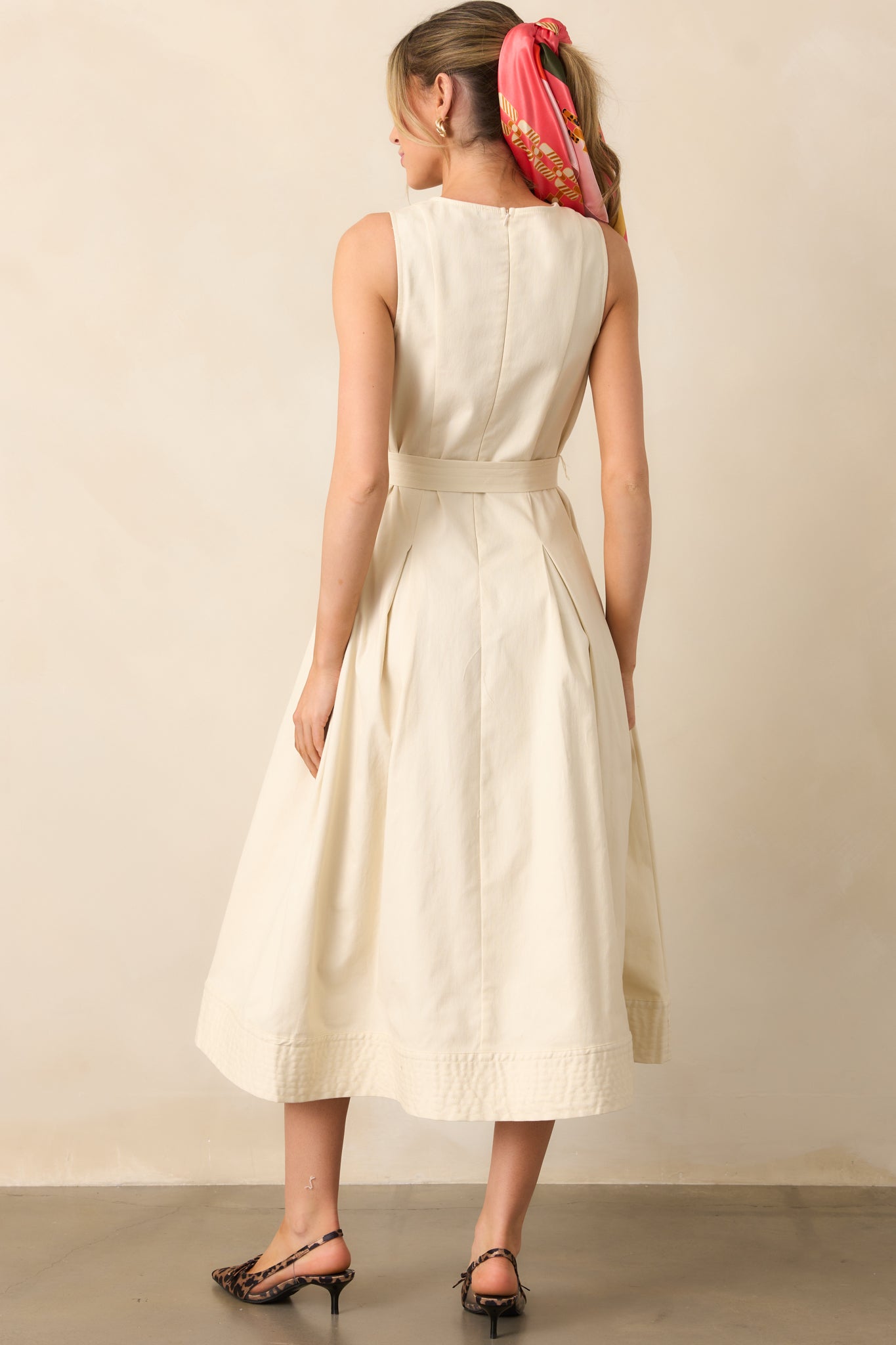 The back of the dress features a discrete zipper for a seamless finish, complementing the structured yet elegant design.