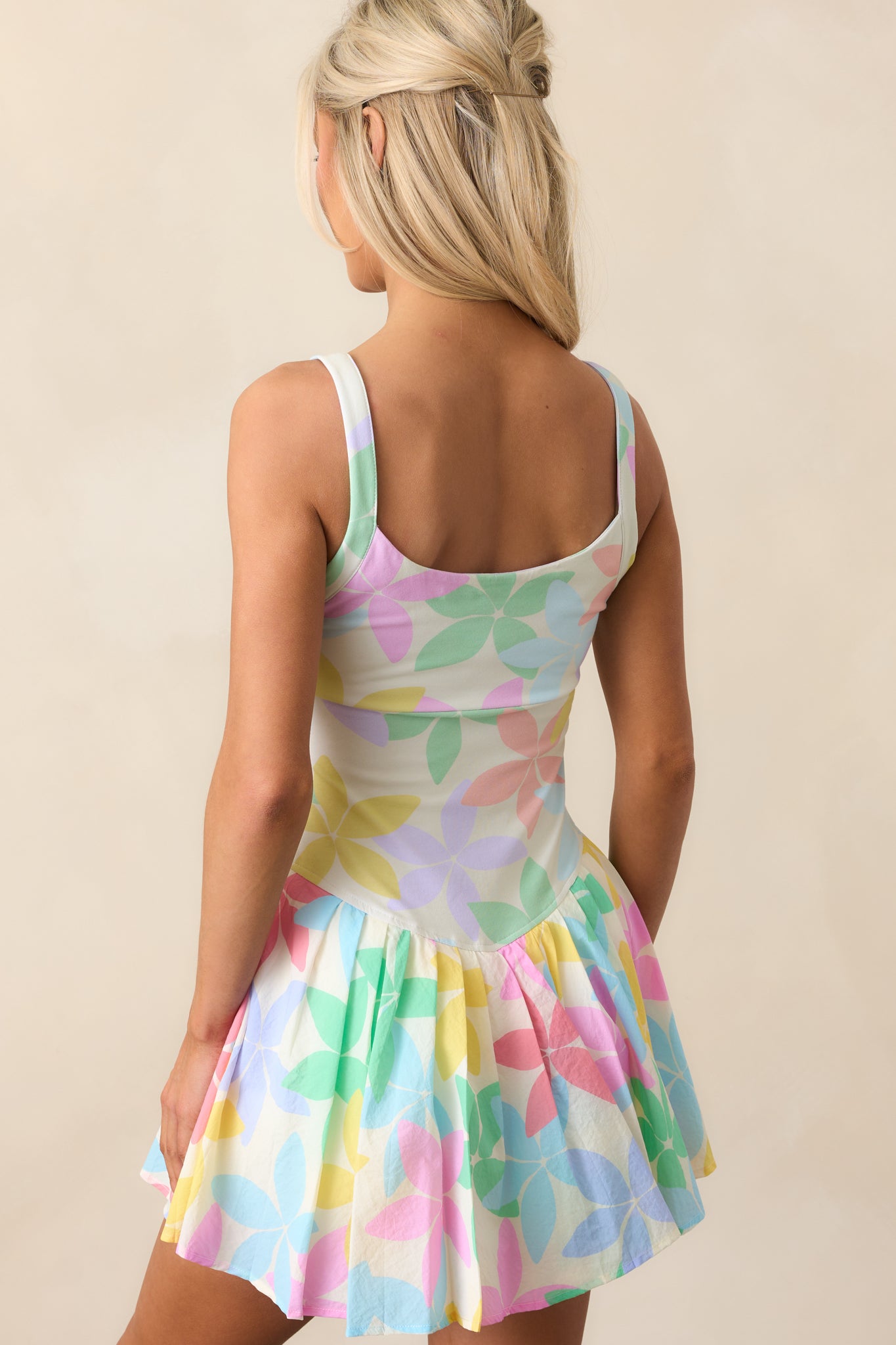 The back of this pastel mini dress keeps it light and airy, with thin straps and a softly pleated silhouette.