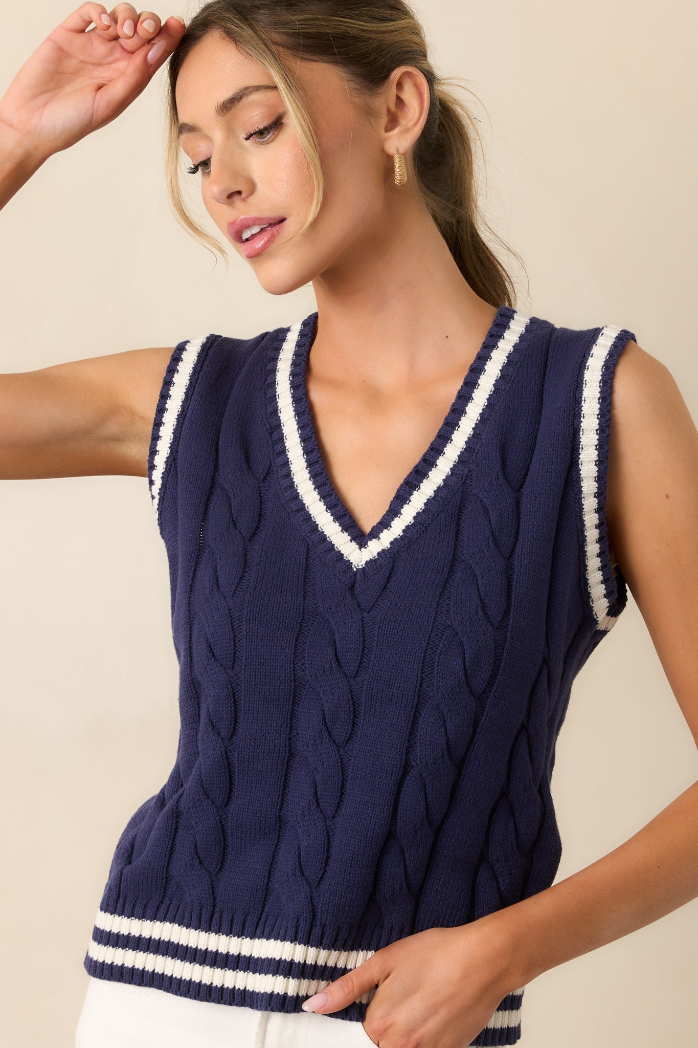 A closer look at the V-neckline, where the ribbed ivory trim adds a bold accent to this navy tank.