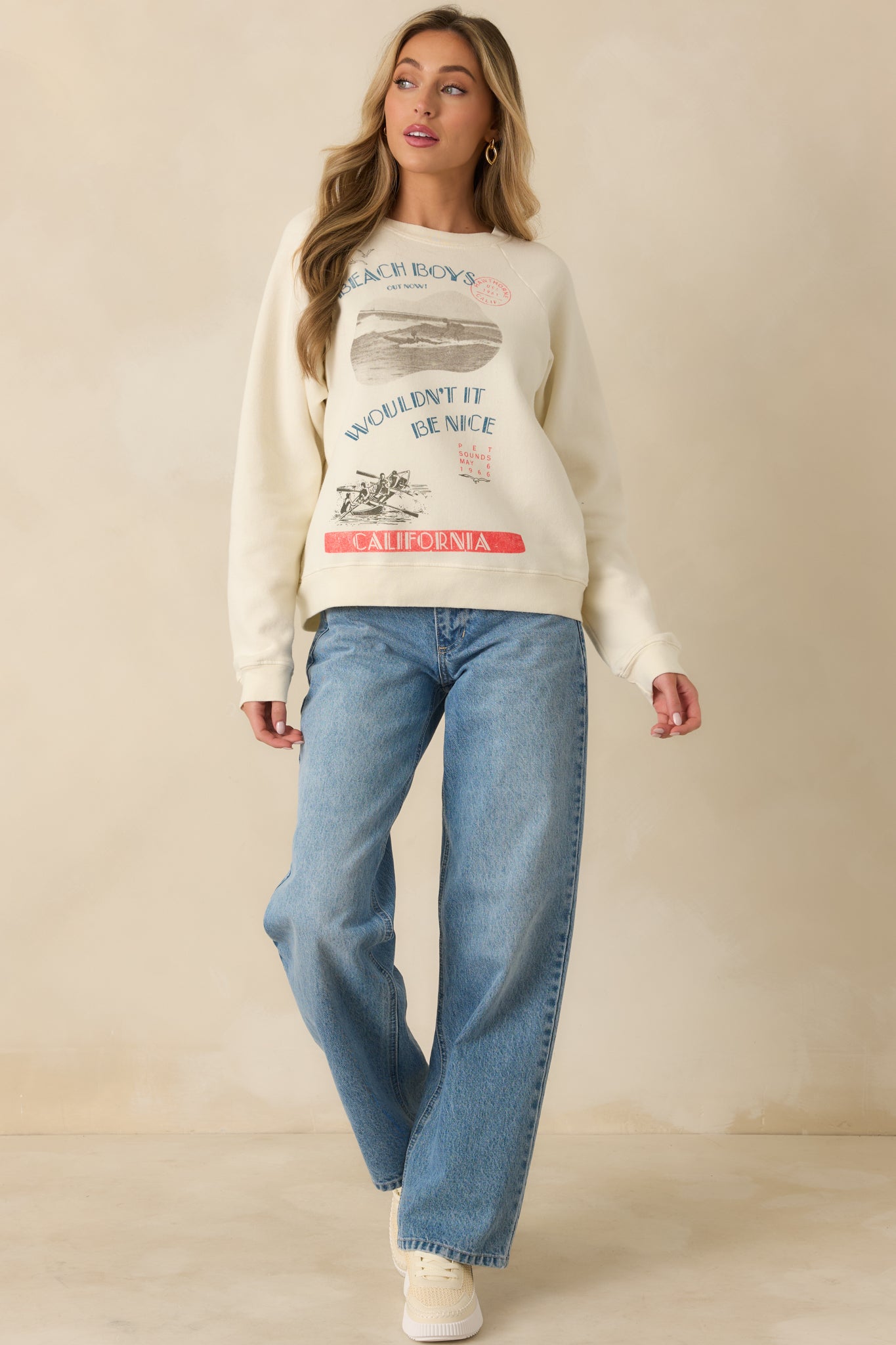 Crewneck raglan top with multi-color beach-themed graphics and casual, relaxed silhouette.