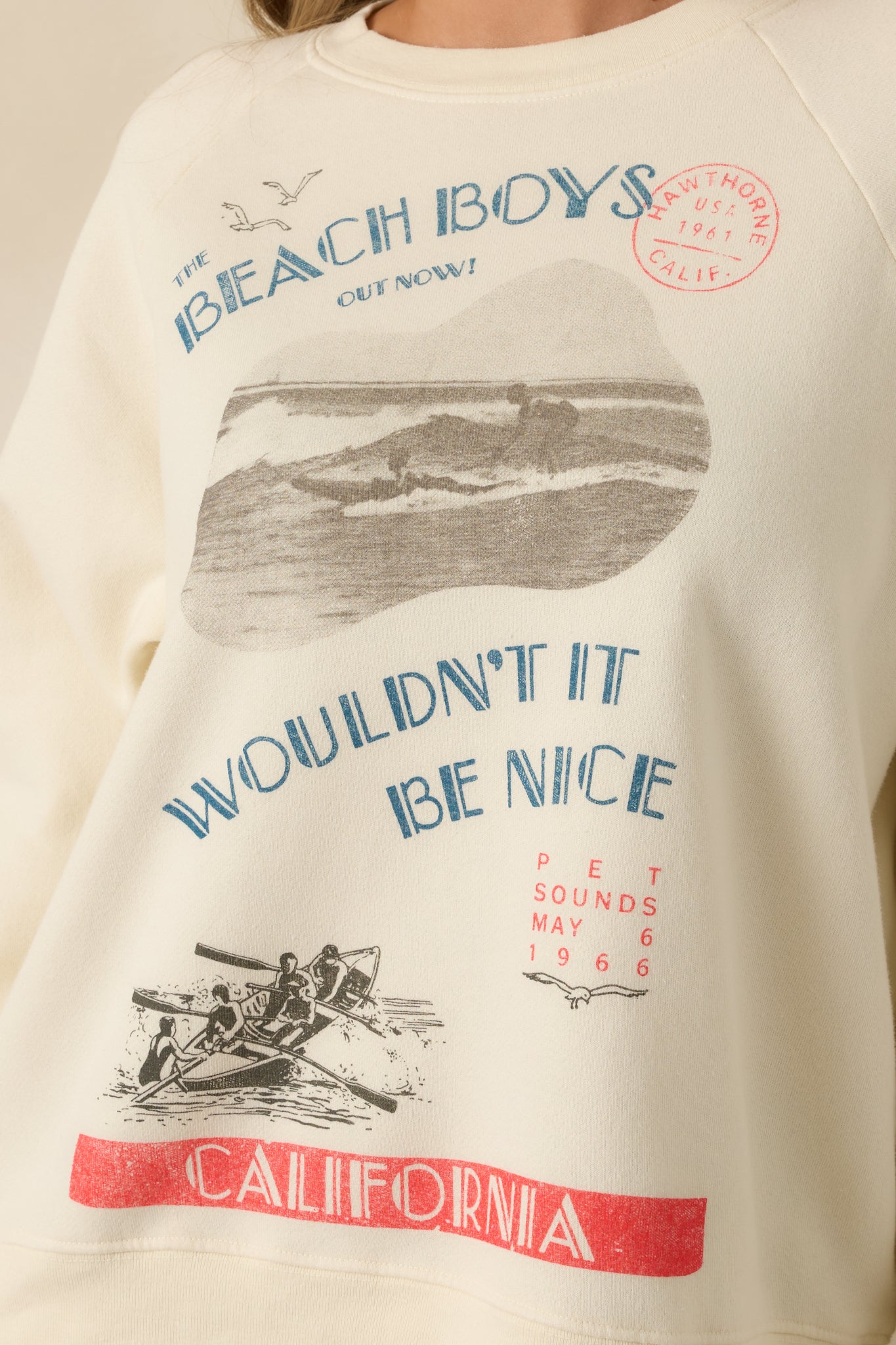 Close-up of the sweatshirt’s chest area showing intricate Beach Boys graphic design, lettering, and California imagery.