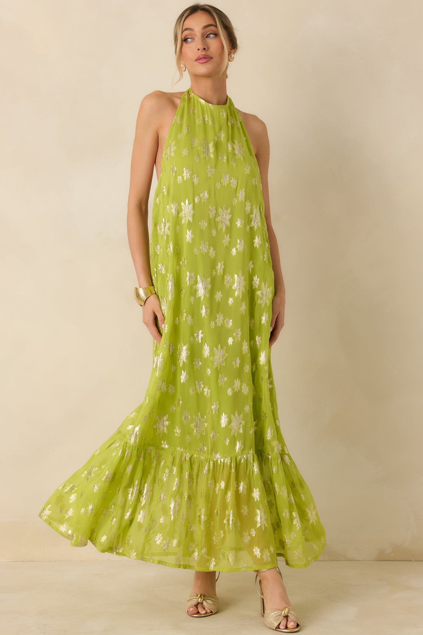 Chartreuse maxi dress featuring a halter neckline, metallic floral detailing, and a relaxed tiered skirt with fluid movement.