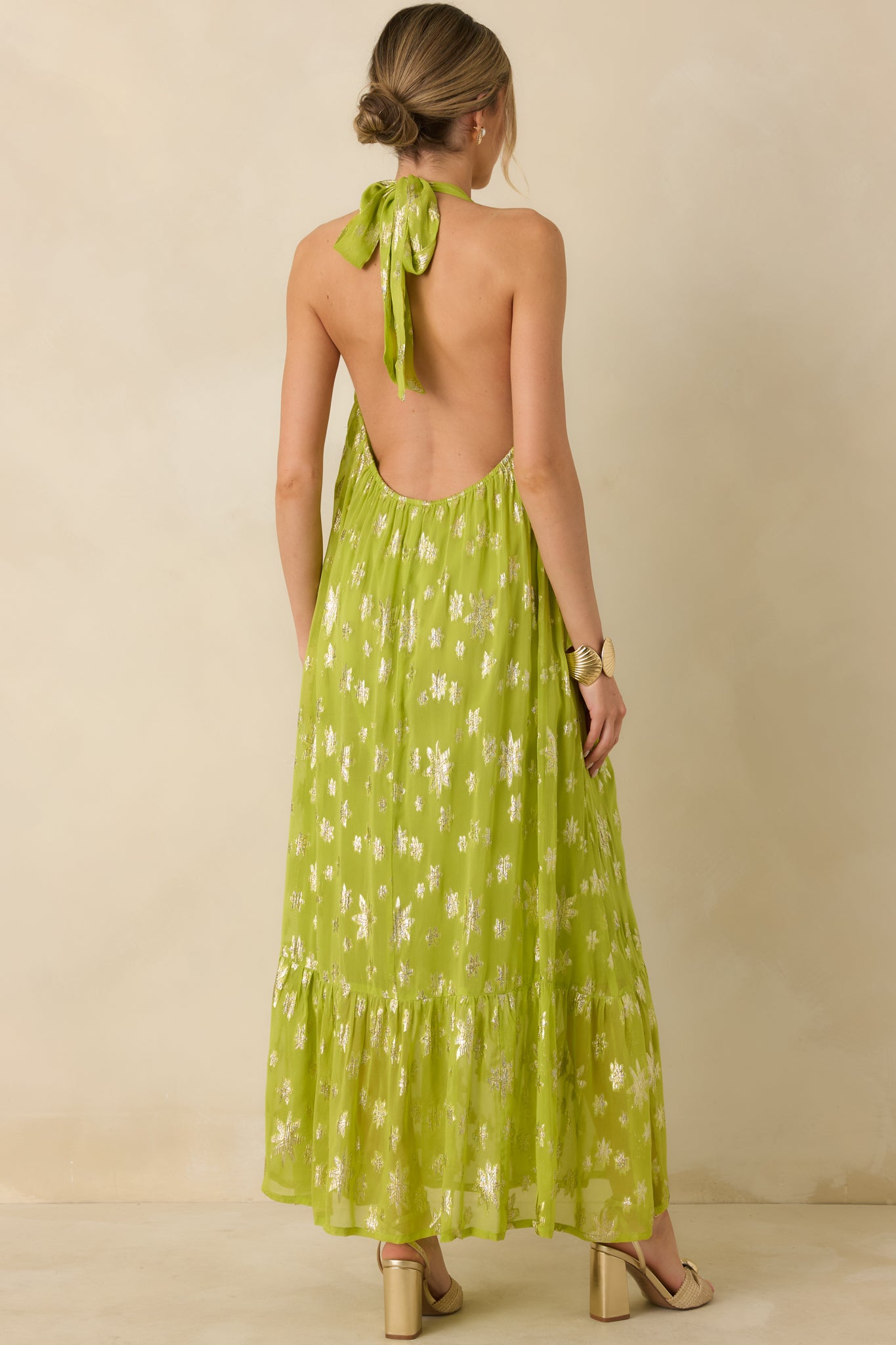Chartreuse maxi dress shown from the rear, featuring a halter tie neckline, open rear design, and elastic smocking for flexible fit.