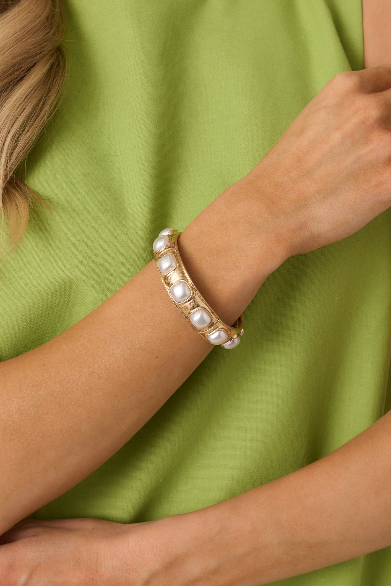 Close view of the pearl square cabochons set within the gold-tone sections on the stretch bracelet.