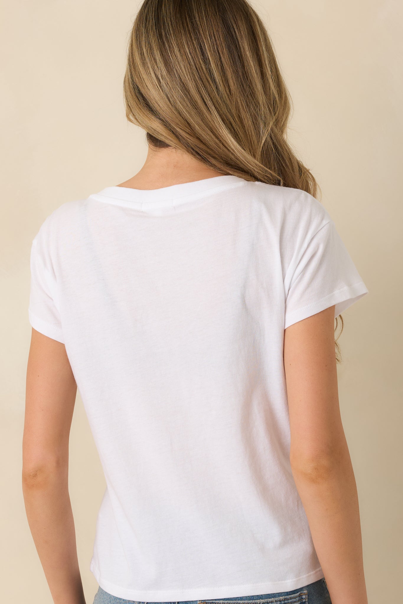 Rear view of white tee highlighting loose short sleeves and relaxed straight silhouette.