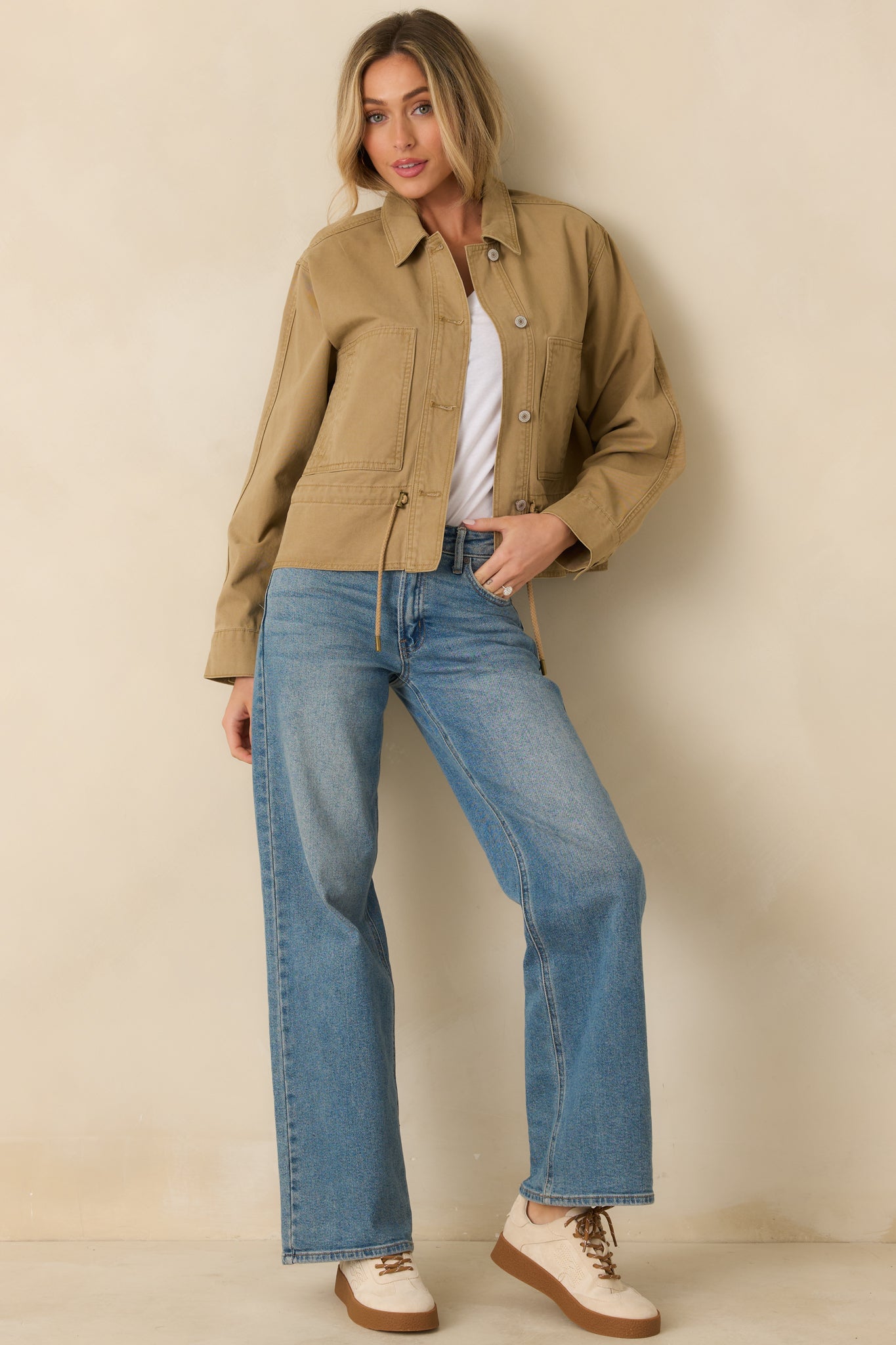 Tan utility jacket with collared neckline, front button closures, long sleeves, and large patch pockets.