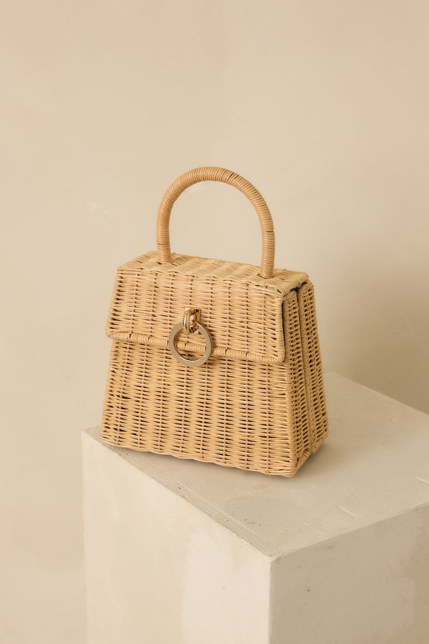 Angled full view of the natural handbag highlighting the expandable sides and structured base.