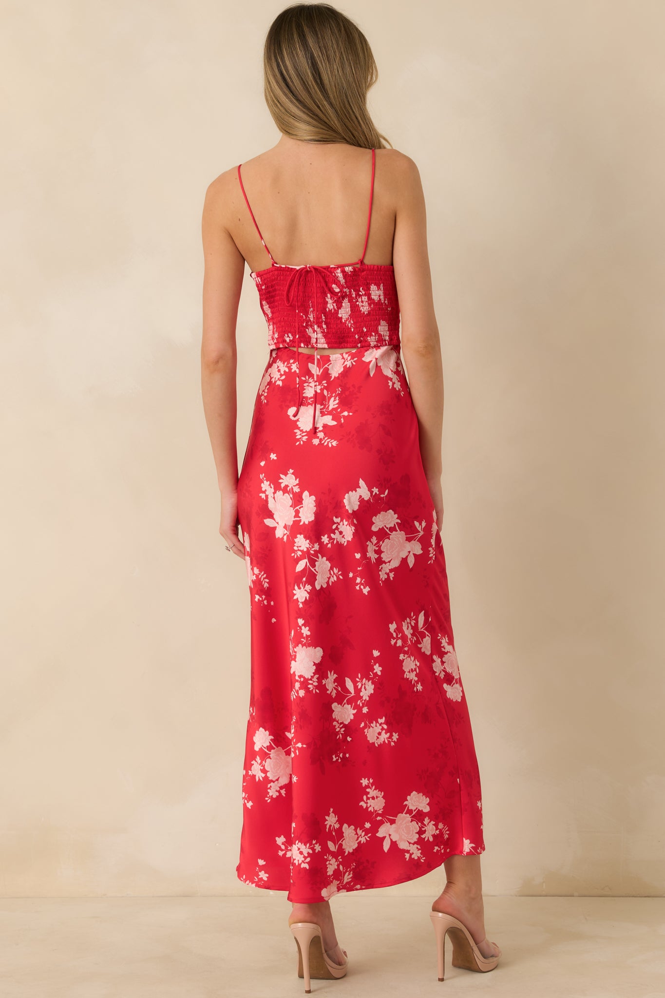 Rear view of the red floral maxi dress highlighting the smocked detail with adjustable tie and flowing skirt.