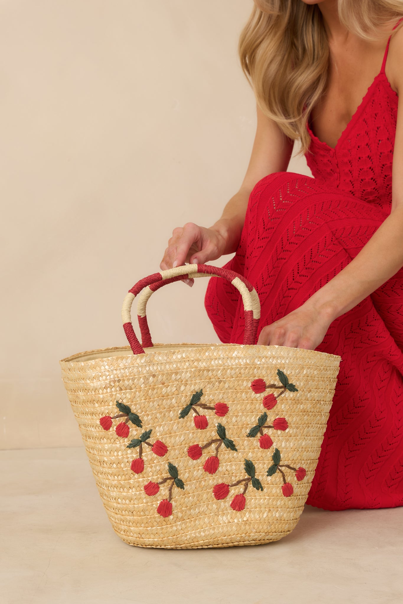Cropped view focusing on the woven straw texture and embroidered cherry pattern across the tote.